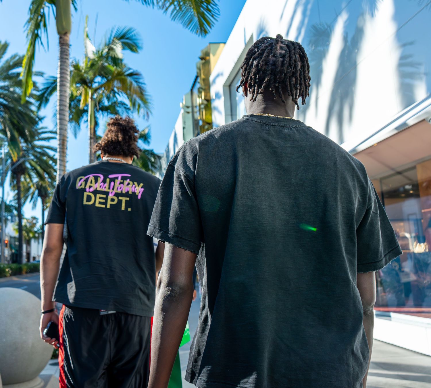 Candid documentary-style photography of two men walking through an urban setting, featuring natural light and authentic storytelling by Shan