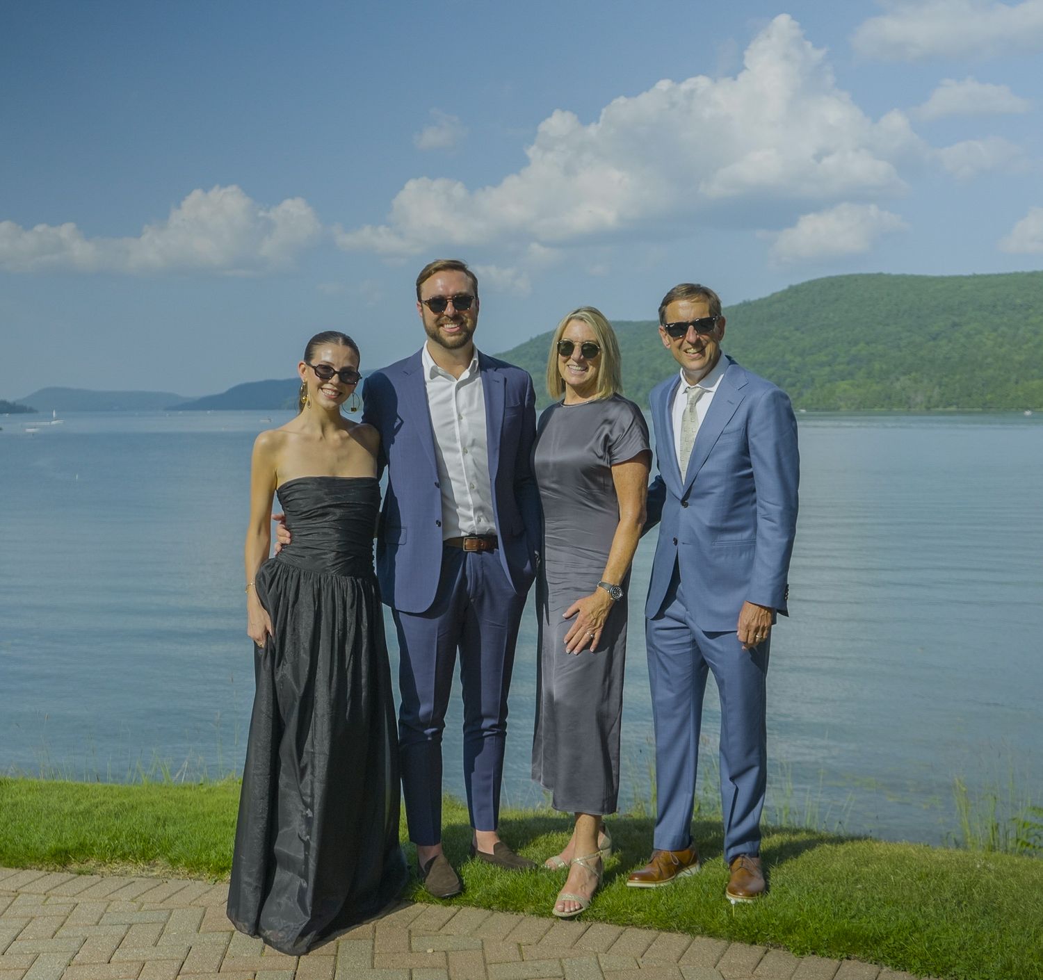 Professional group portrait of four people in formal attire by a scenic lake, showcasing premium lifestyle photography by Shane Anthony.