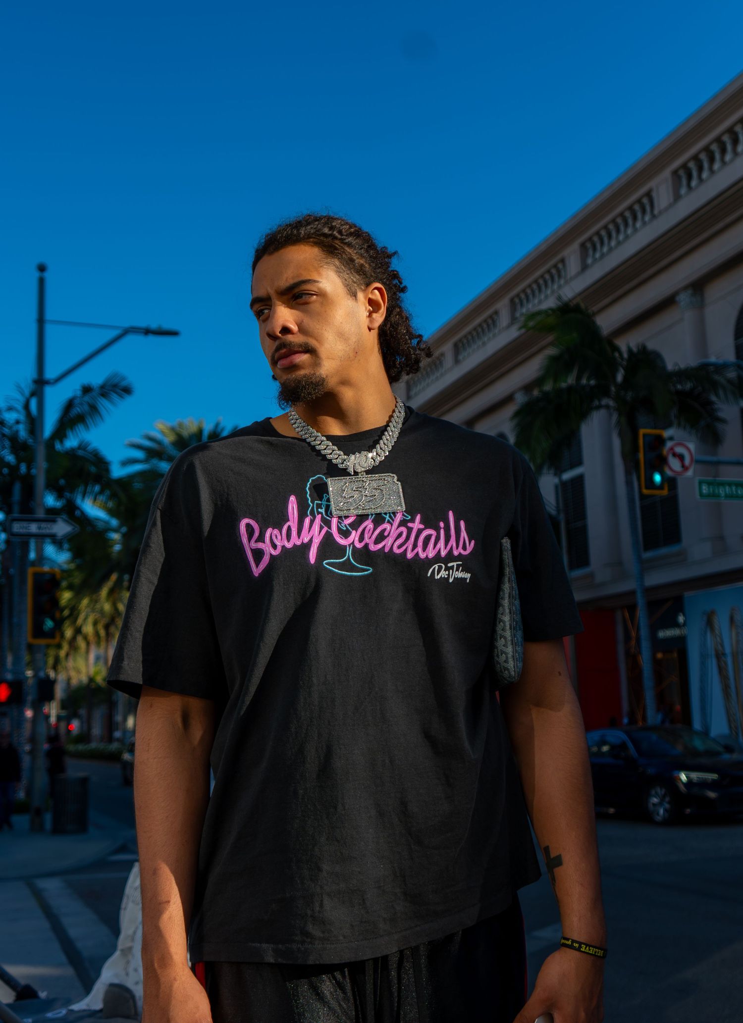 Editorial urban fashion photography featuring a man in a streetwear graphic tee against a city backdrop, shot by Shane Anthony.