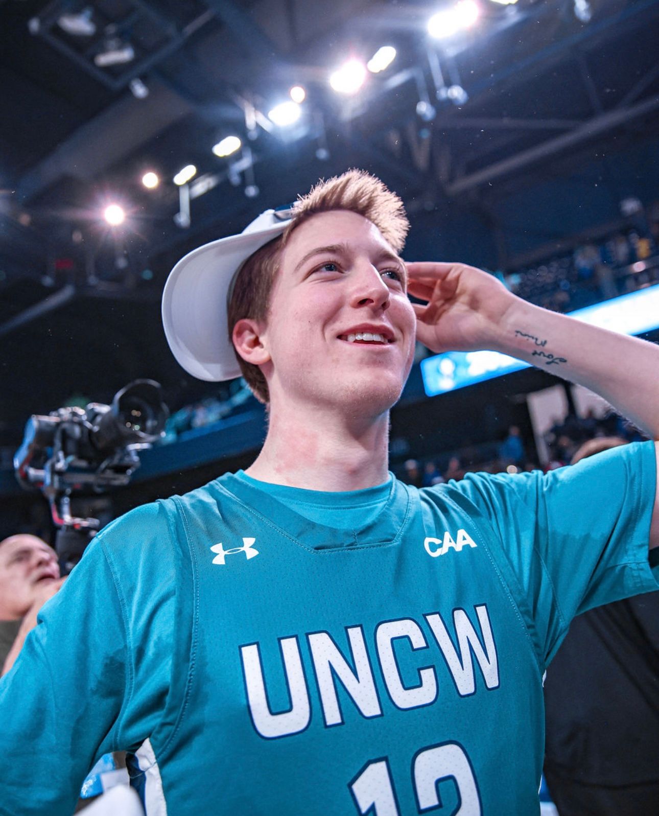 Action sports fan portrait featuring a young man in a UNCW jersey, illustrating authentic event photography by Shane Anthony.