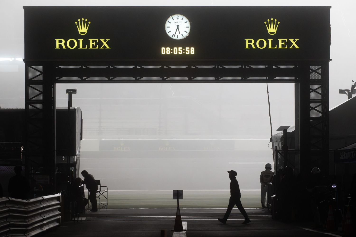 Rolex clock gate at misty Daytona race circuit at dawn.