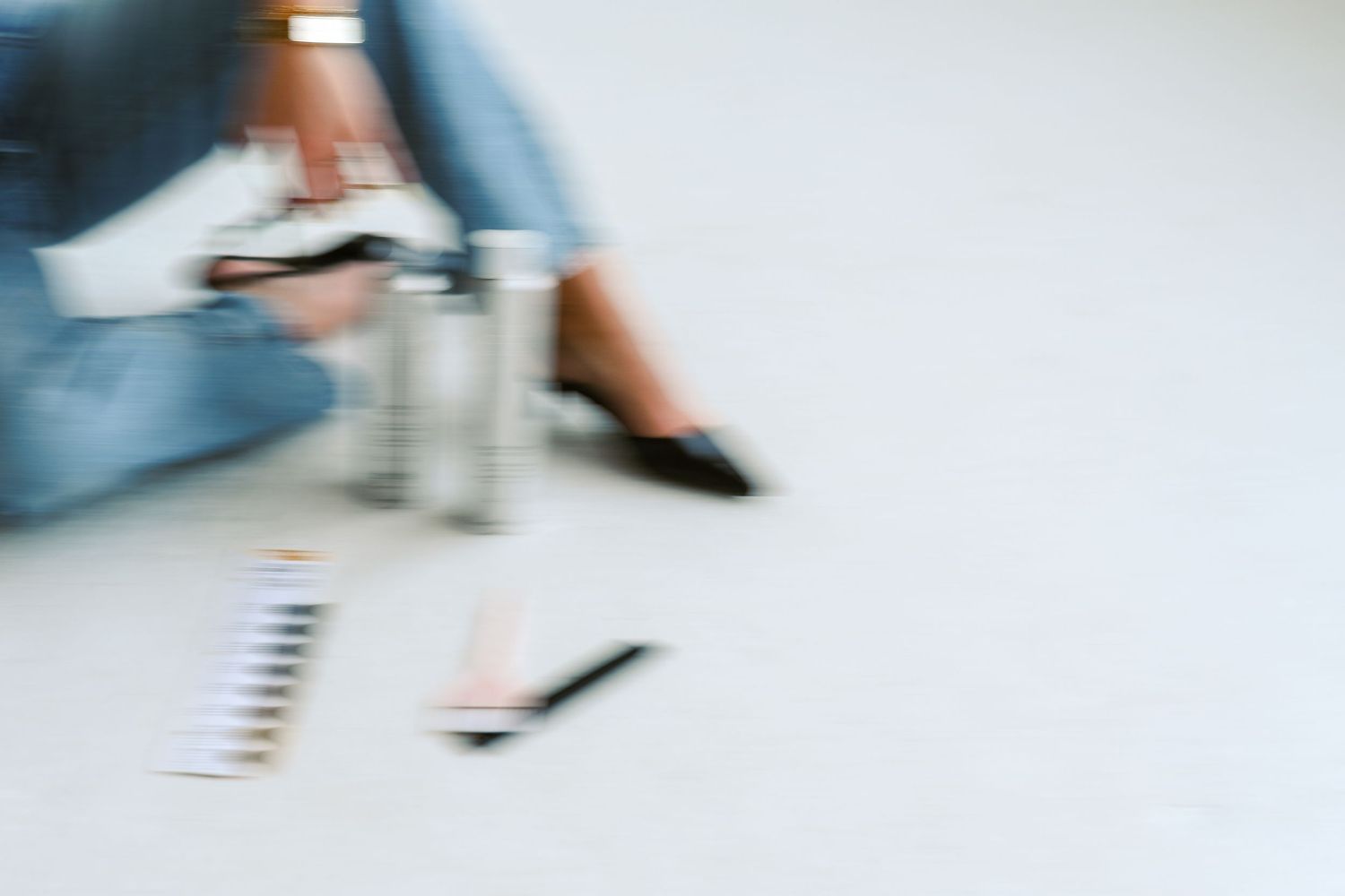 Blurred motion shot of person sitting on floor with hair color swatches.
