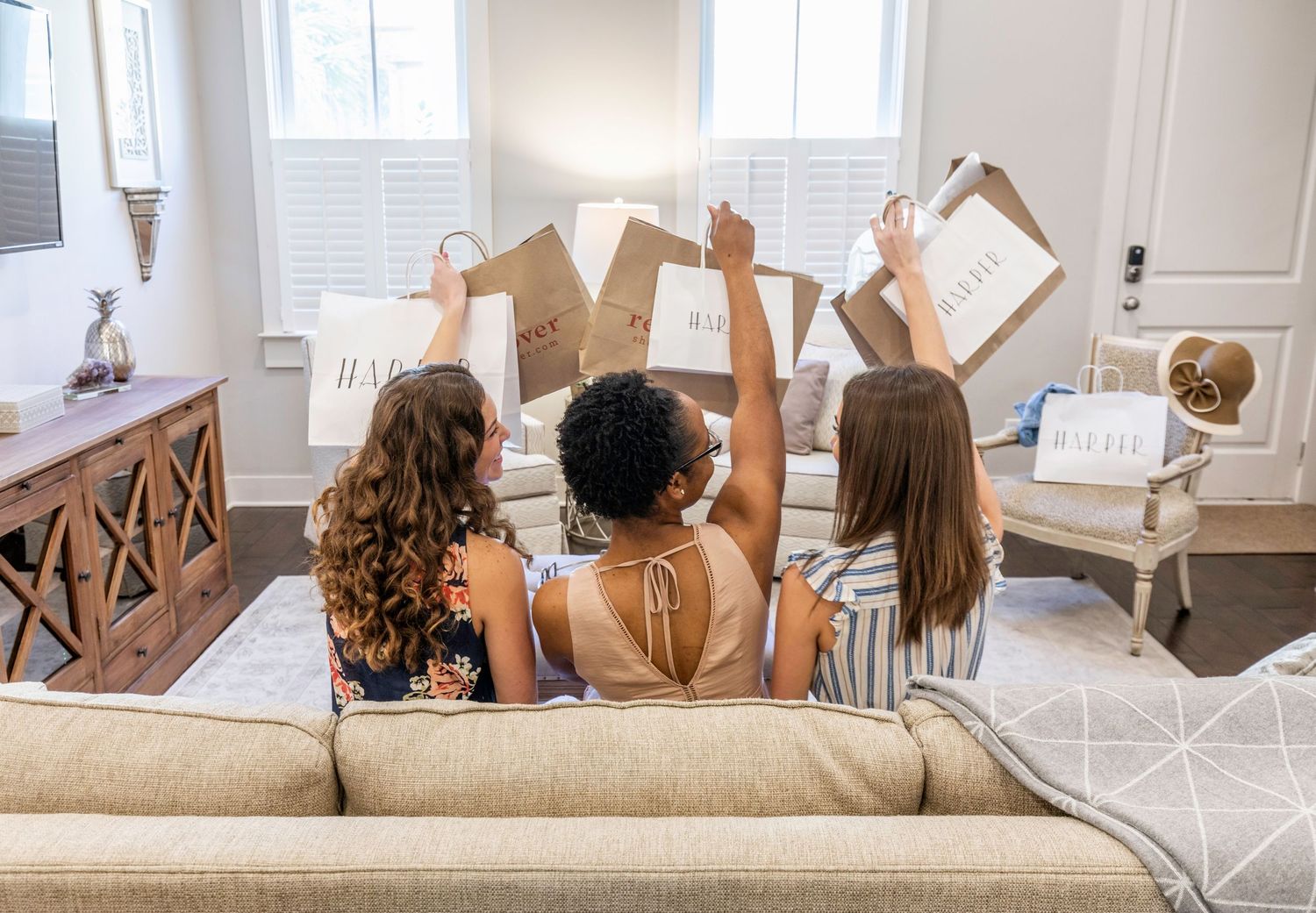 Three women with shopping bags in the living room of a Savannah vacation rental
