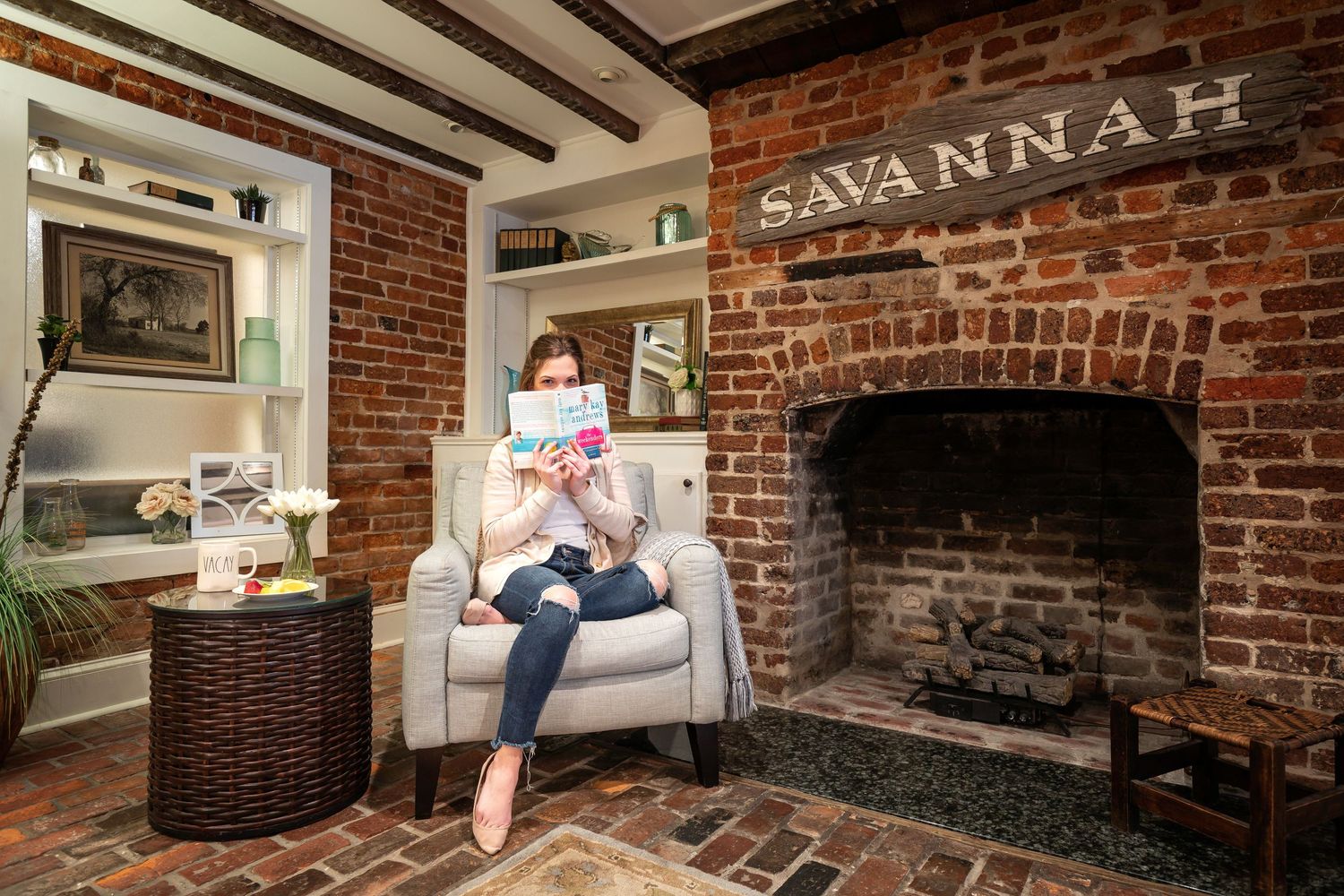 Woman reading on a chair in the living room of a Savannah vacation rental