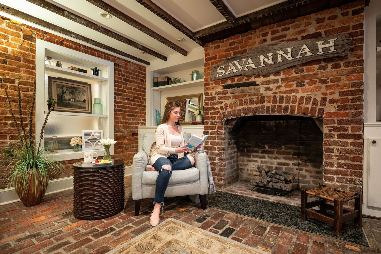 Woman reading on a chair in the living room of a Savannah vacation rental