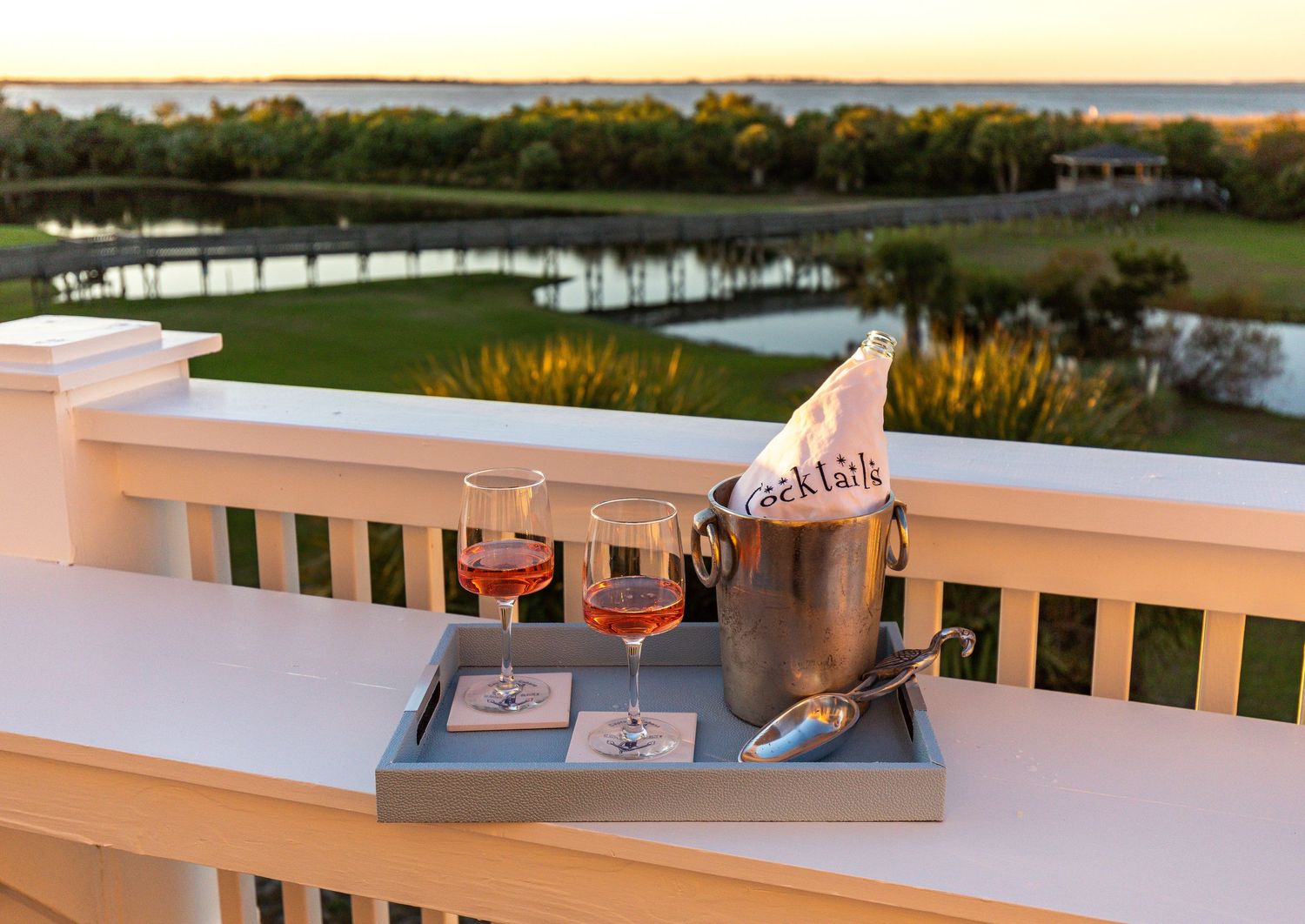 Cocktail tray with copper Moscow Mule mugs and a cocktail shaker on a deck overlooking the marsh at a Tybee Island vacation rental