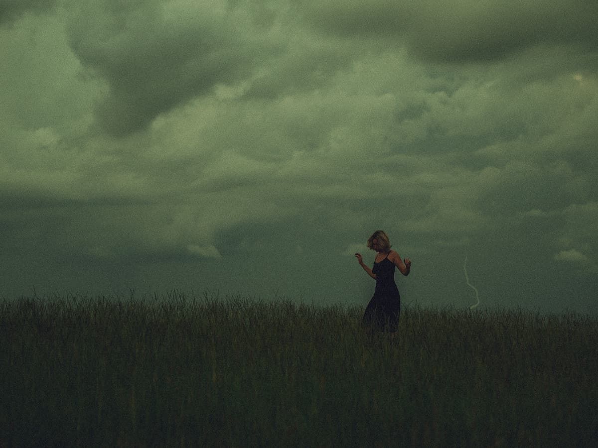 A dark and moody portrait under stormy green skies creates an eerie atmosphere in Spartanburg, SC.