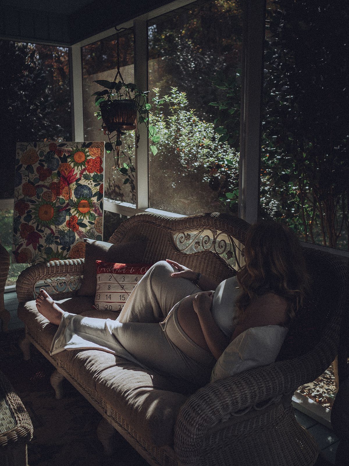 Nature-based maternity portrait indoors with soft window light and woodland views near Greenville, South Carolina
