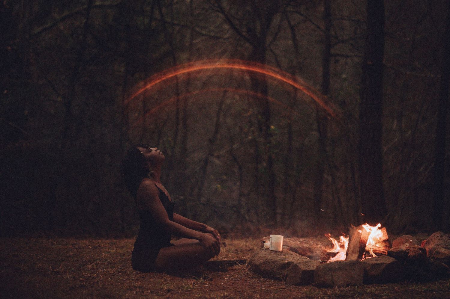Witchy, ecosomatic boudoir photograph of a woman meditating next to a fire in Spartanburg, SC.
