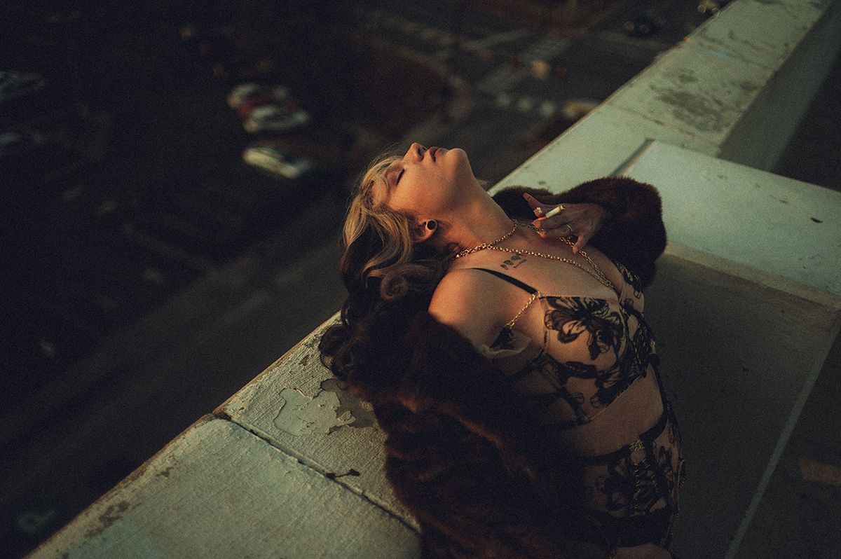 Dark and moody cinematic boudoir showing someone on top of a parking garage in dramatic lighting in Greenville, South Carolina.