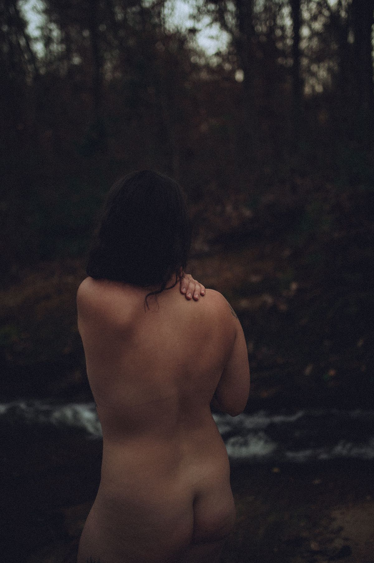 Dark and moody artistic nude boudoir photo in river near Spartanburg, South Carolina.