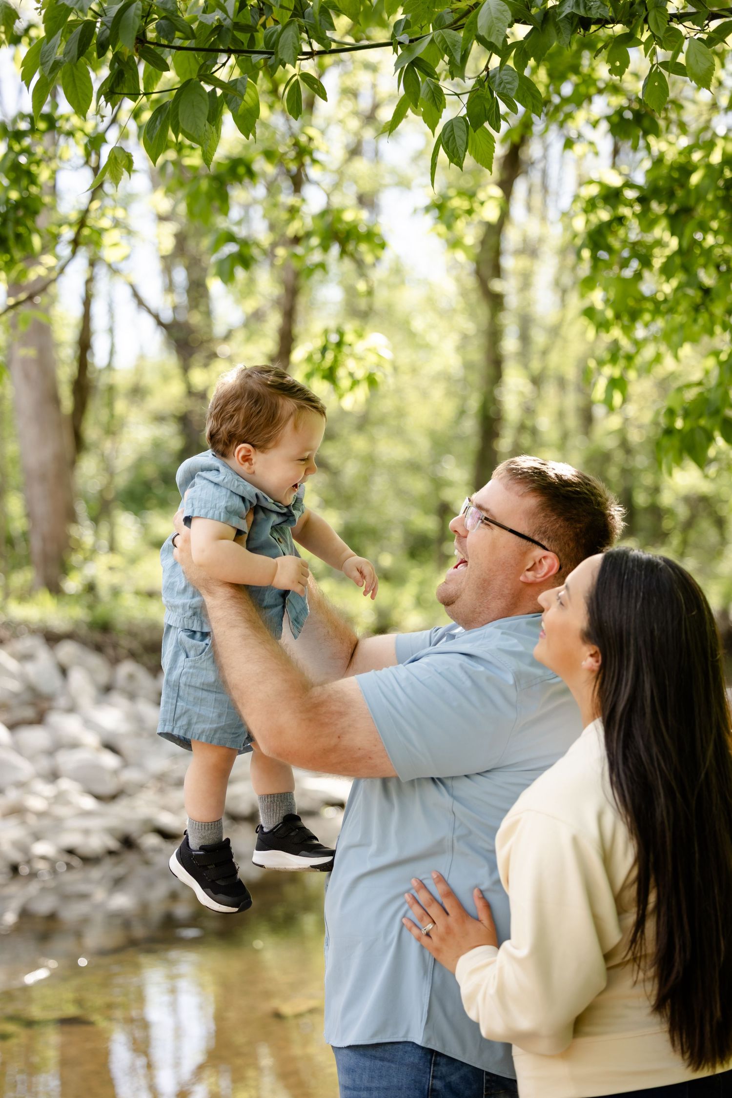 Happy family by creek for family photoshoot at Arbuckle Acres Park in Brownsburg, Indiana by Katy Rose Photography.