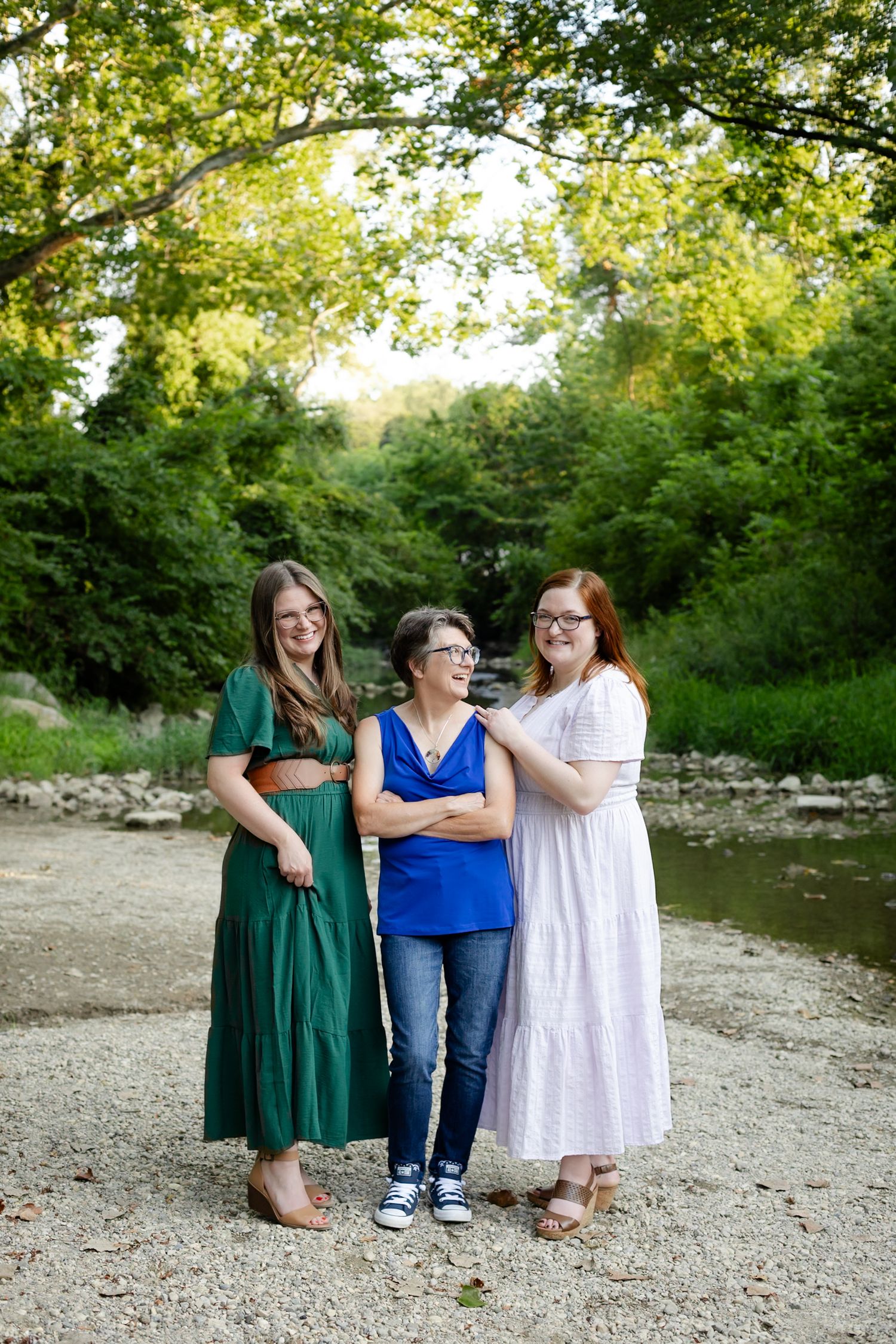 Mother and daughters posing together by a creek during family photos at Ellis Park in Danville, Indiana by Katy Rose Photography.