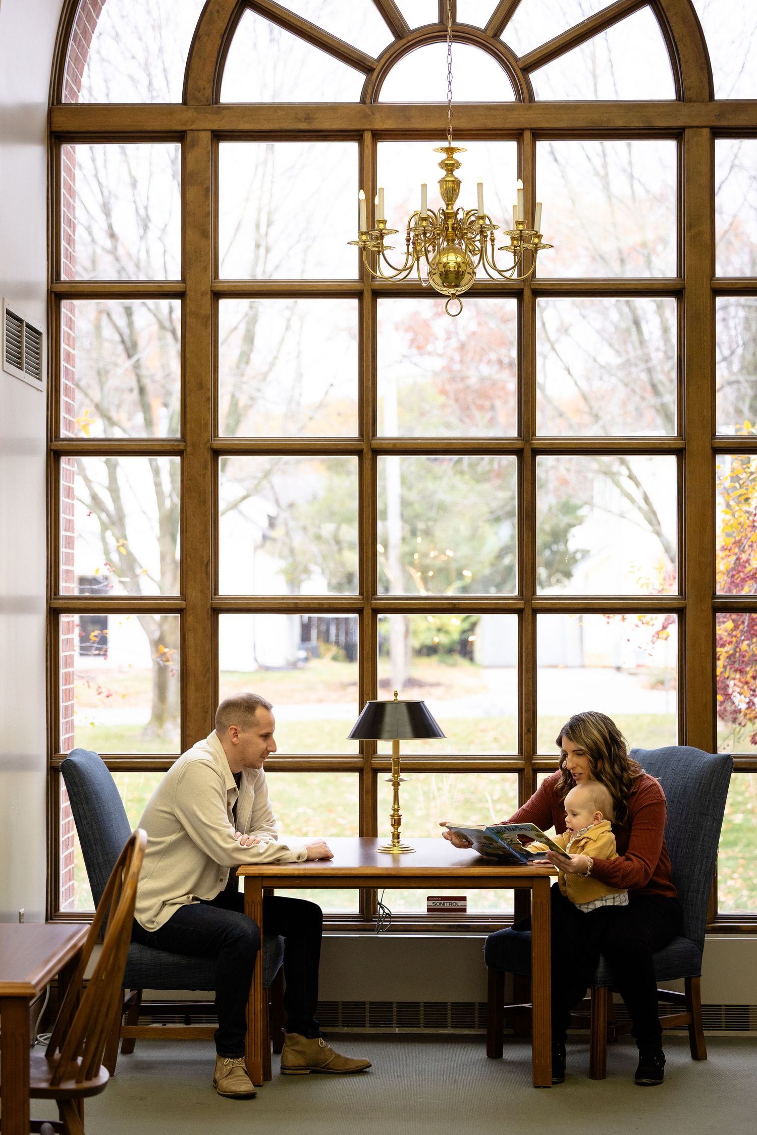 Interior of room with large arched windows and people sitting at tables for first birthday session in Zionsville by Katy Rose Photography