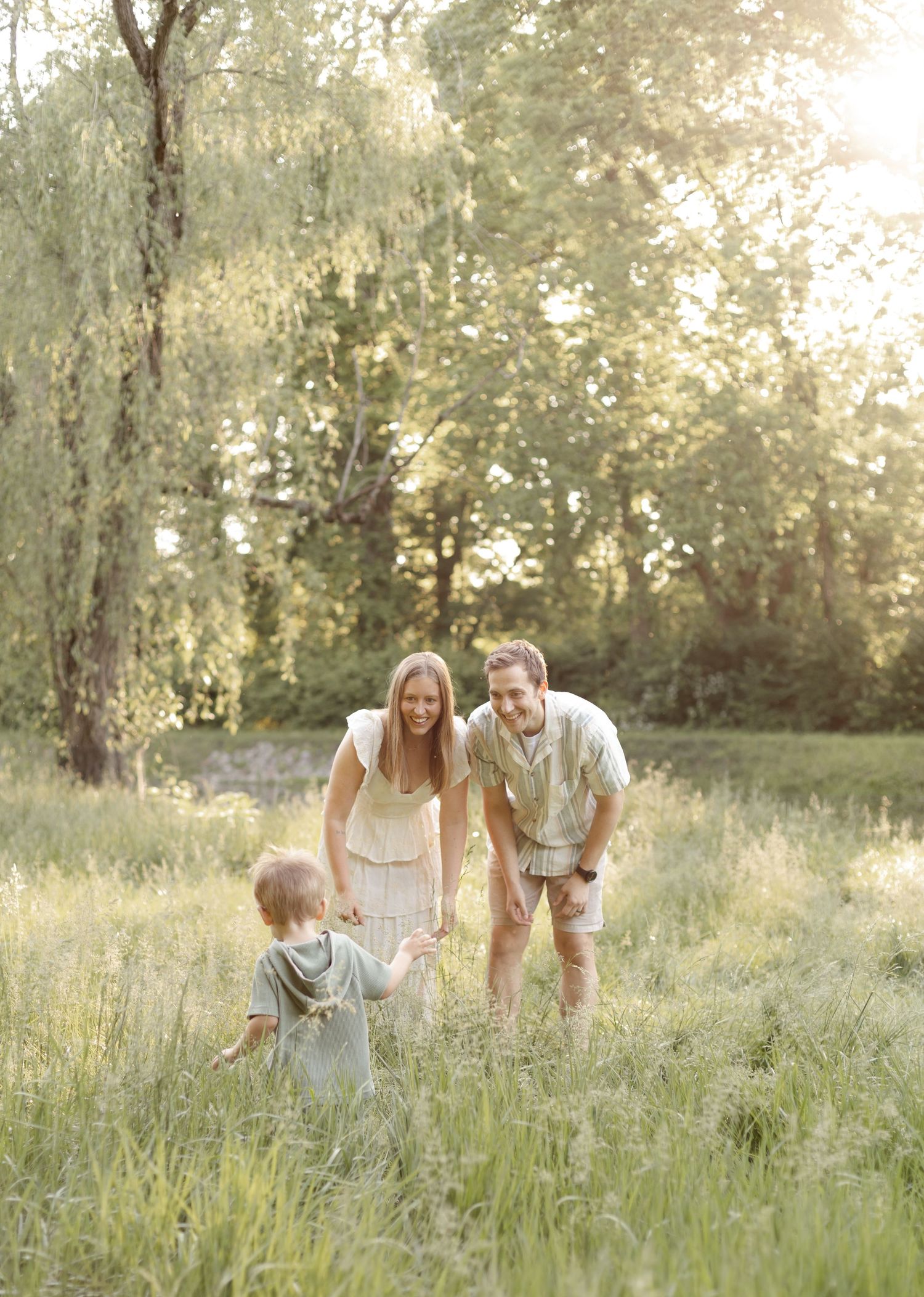 Family playing together in tall grass during golden hour sunset family photoshoot at Holcomb Gardens by Katy Rose Photography.