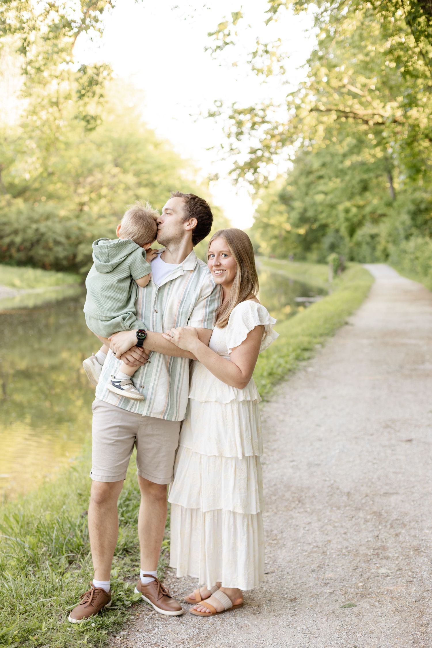 Family sharing playful moments on a sunlit nature path during family photos in Indianapolis by Katy Rose Photography.