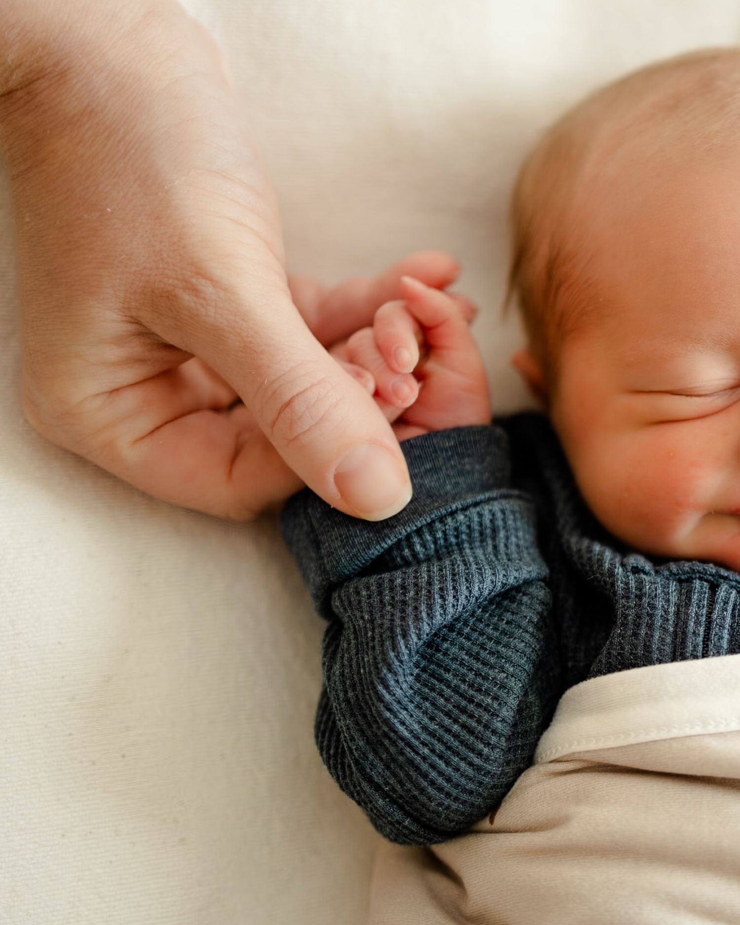 Close-up of newborn holding mom's finger during newborn session in Hendricks County. by Katy Rose Photography.