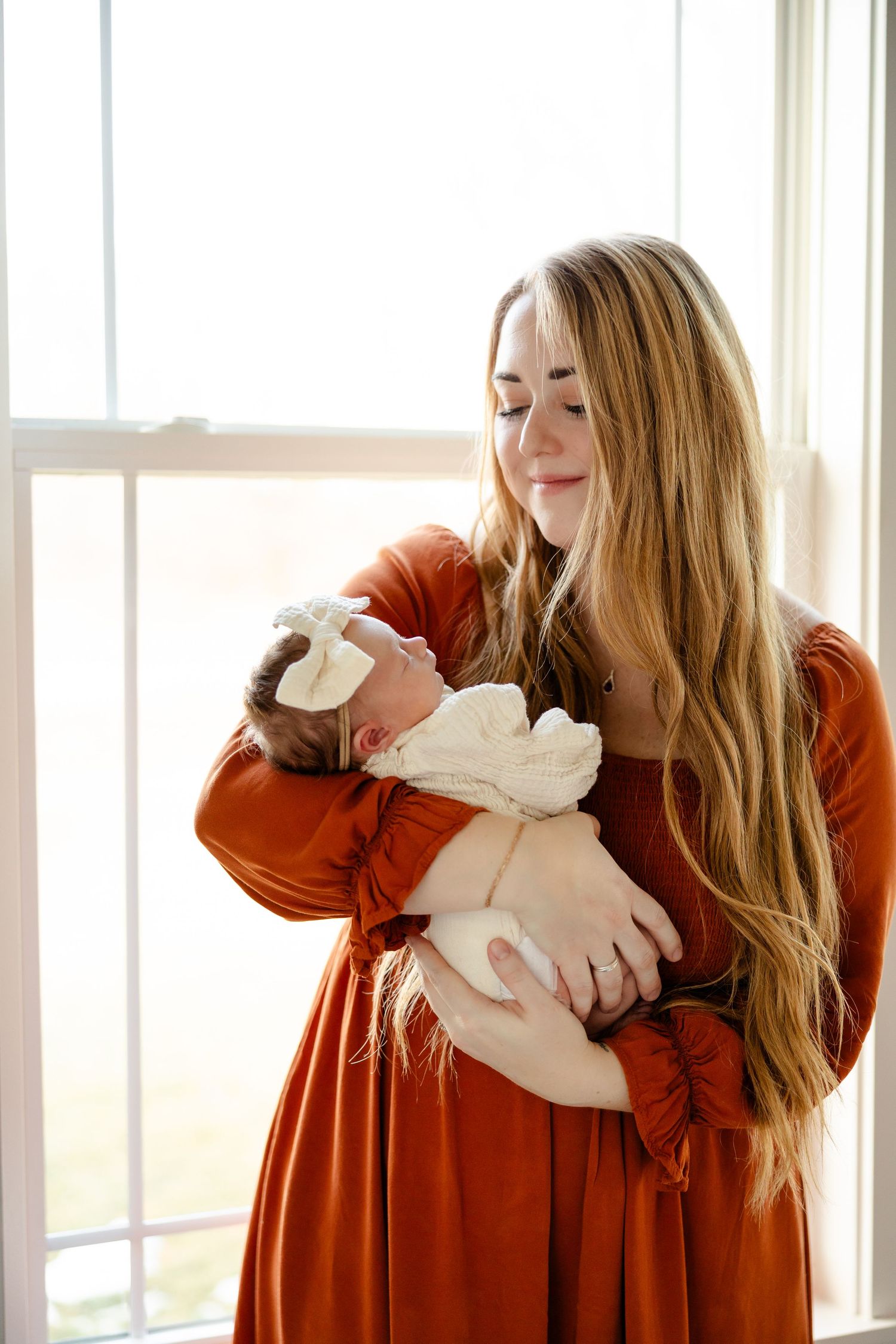 Mom holding baby girl during in-home newborn session in Hendricks County by Katy Rose Photography.