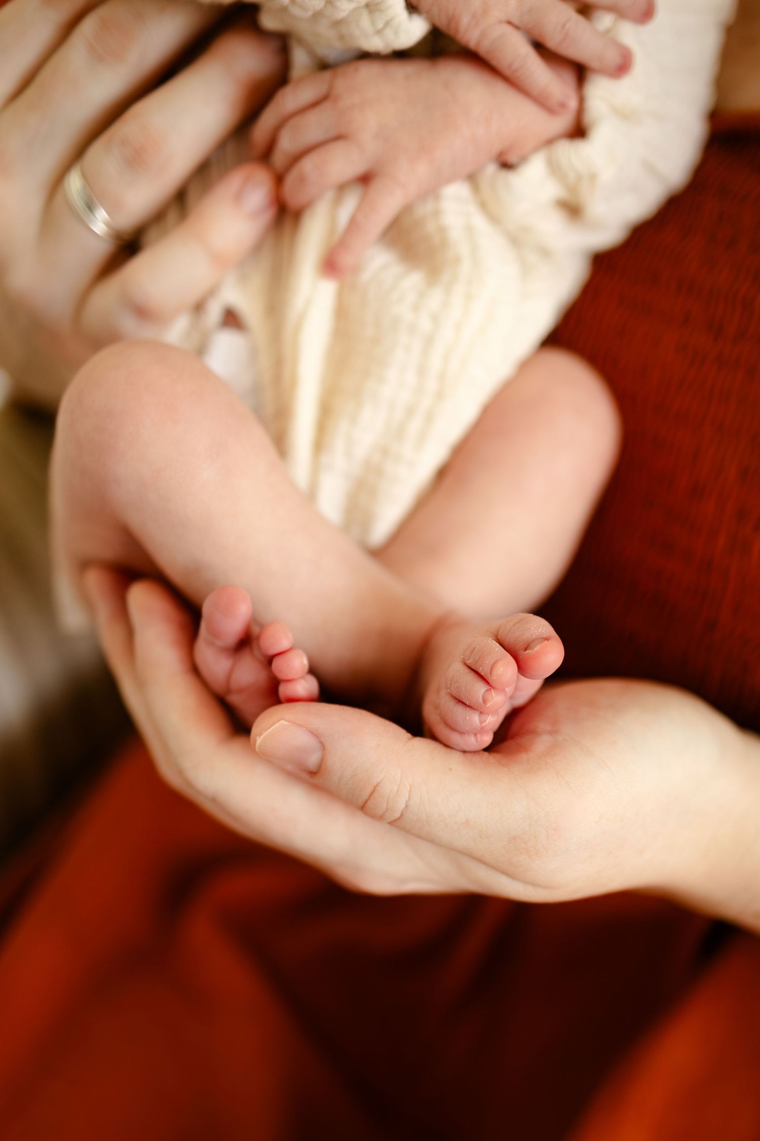 Tiny baby feet being gently cradled in mom's hands during in-home newborn session in Hendricks County by Katy Rose Photography