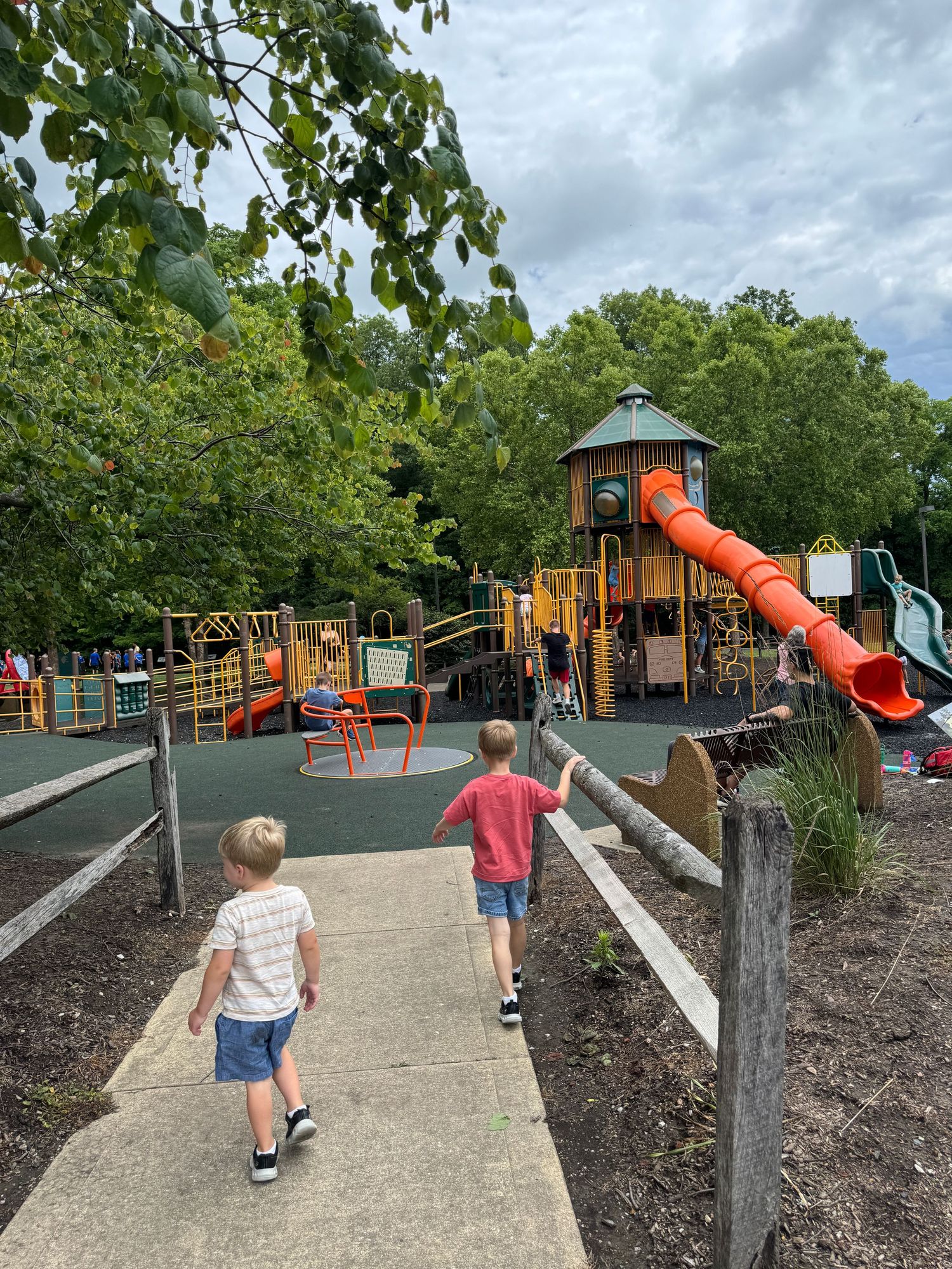 Two young boys walking toward a colorful playground at Washington Township Park in Avon, Indiana Hendricks County