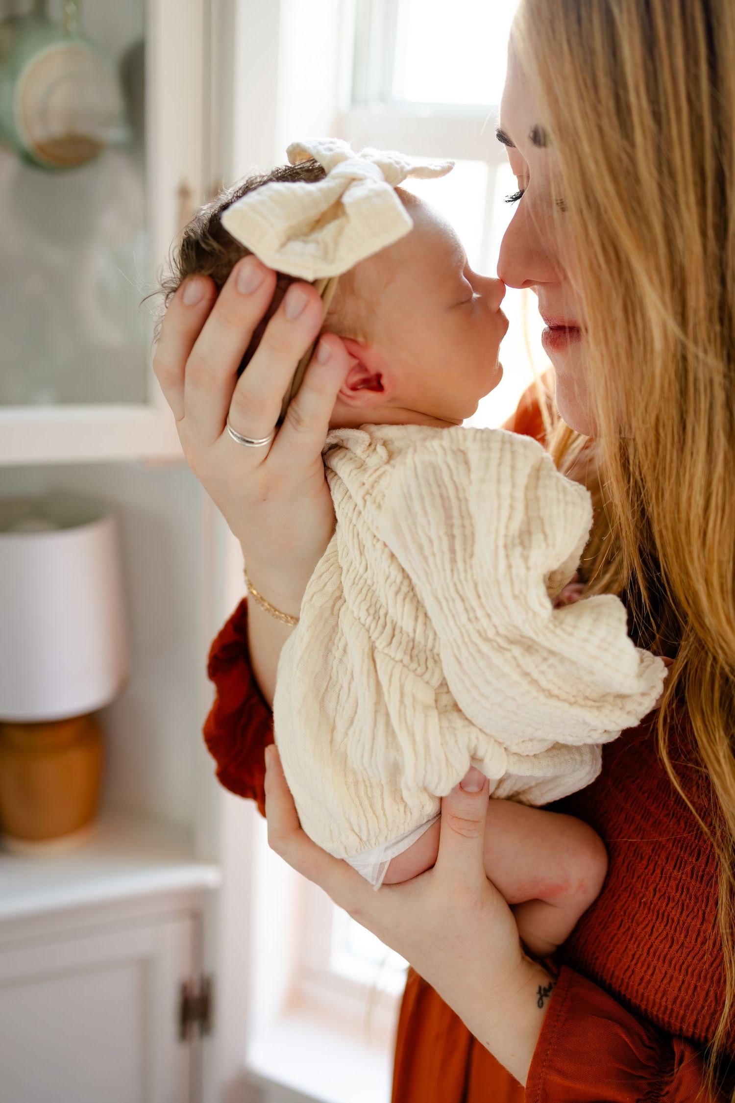 Mom and baby touching noses during in-home lifestyle newborn session in Mooresville, Indiana by Katy Rose Photography