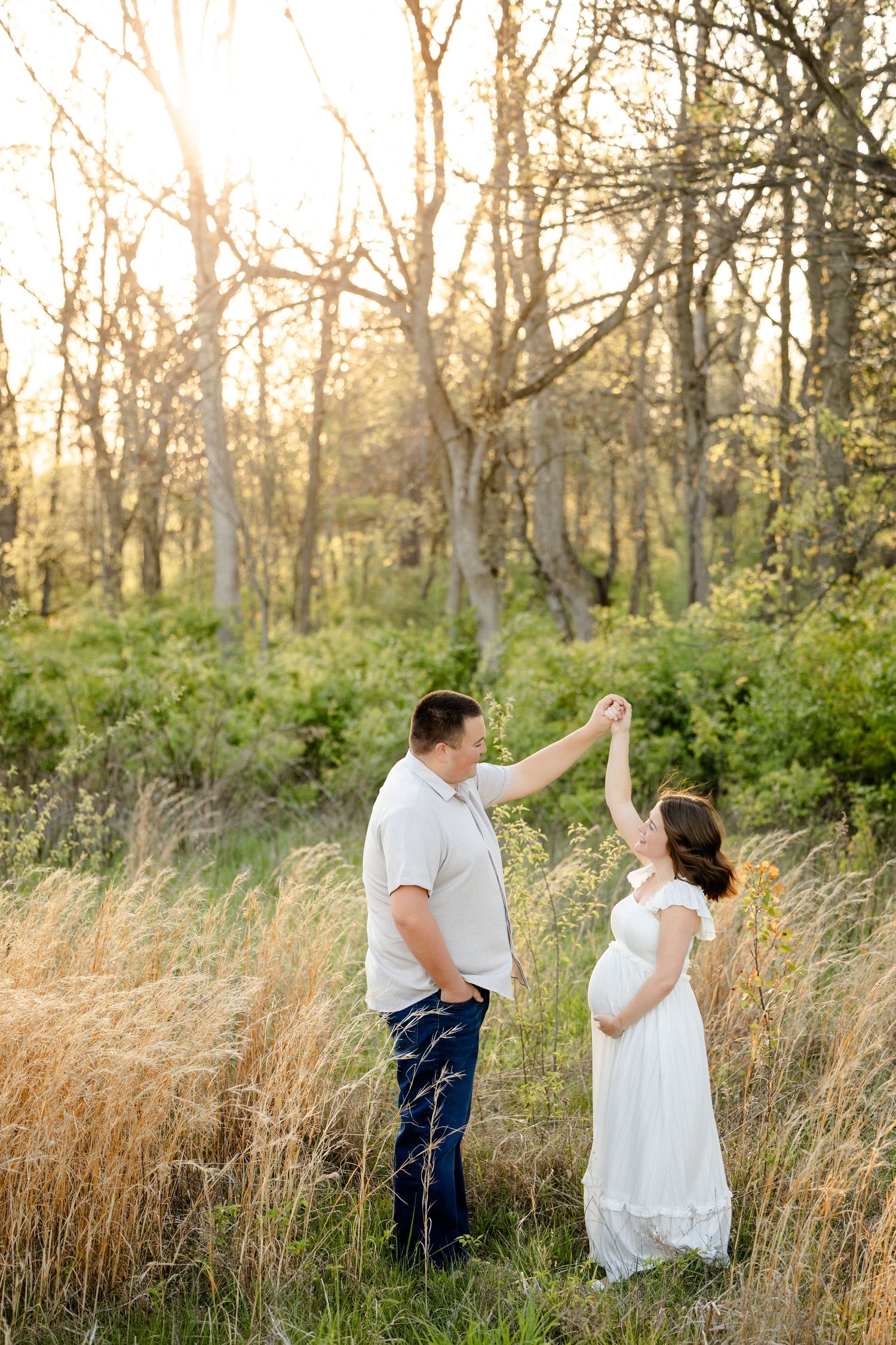 Couple dancing in a field, pregnant woman in white dress during Hendricks County maternity photoshoot by Katy Rose Photography