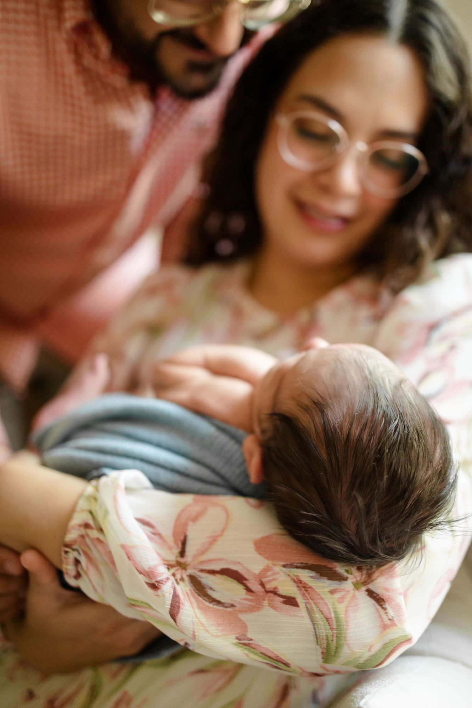 Parents gaze at their newborn during a family portrait at their Indianapolis In-Home Newborn Session by Katy Rose Photography.