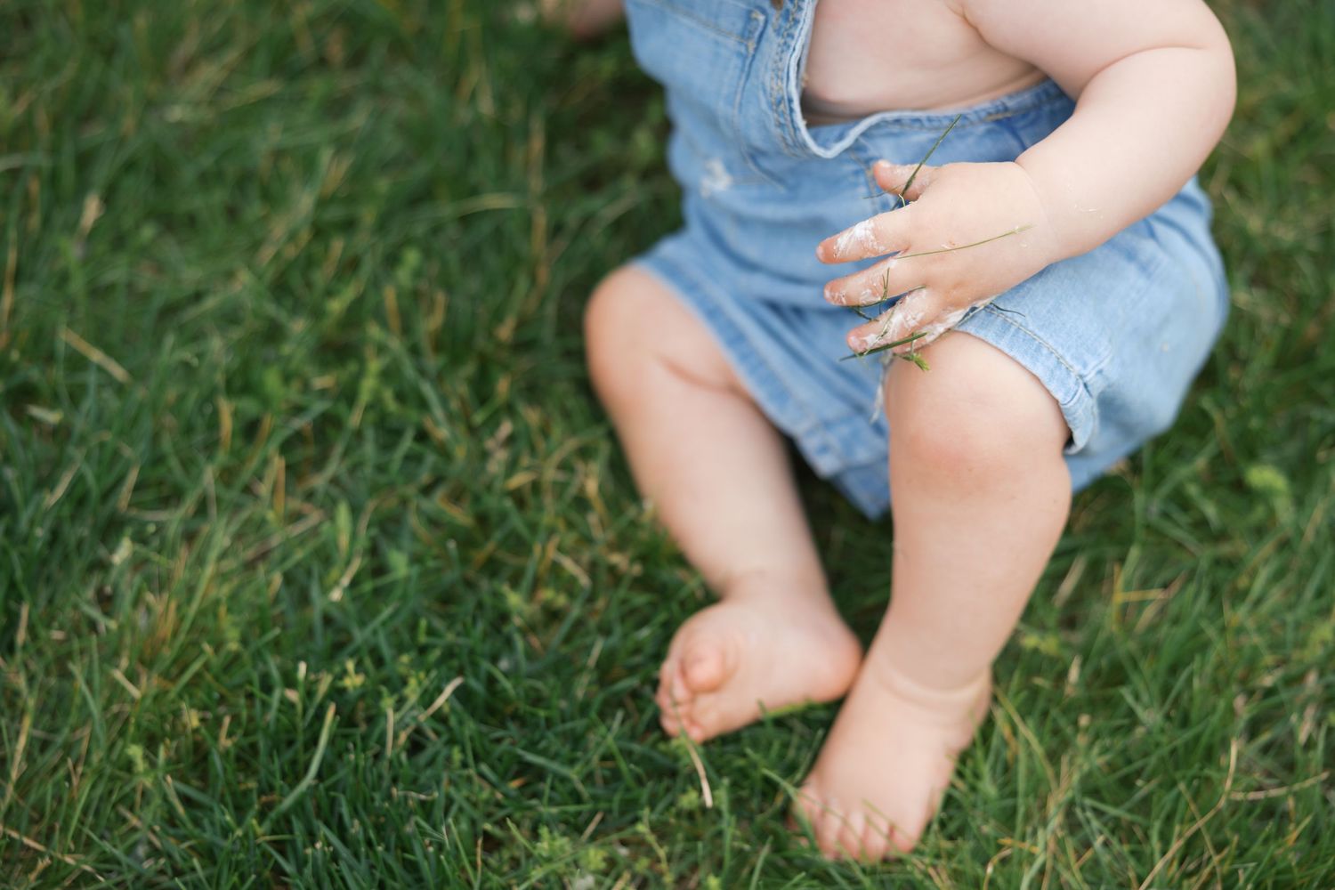 Baby in grass with grassy hands during family session in Indianapolis by Katy Rose Photography.