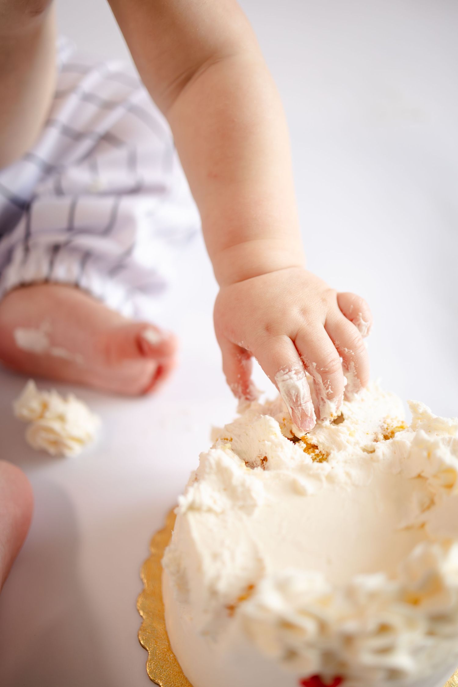 Small hands squish and play with cake for cake smash session in Brownsburg, IN by Katy Rose Photography.