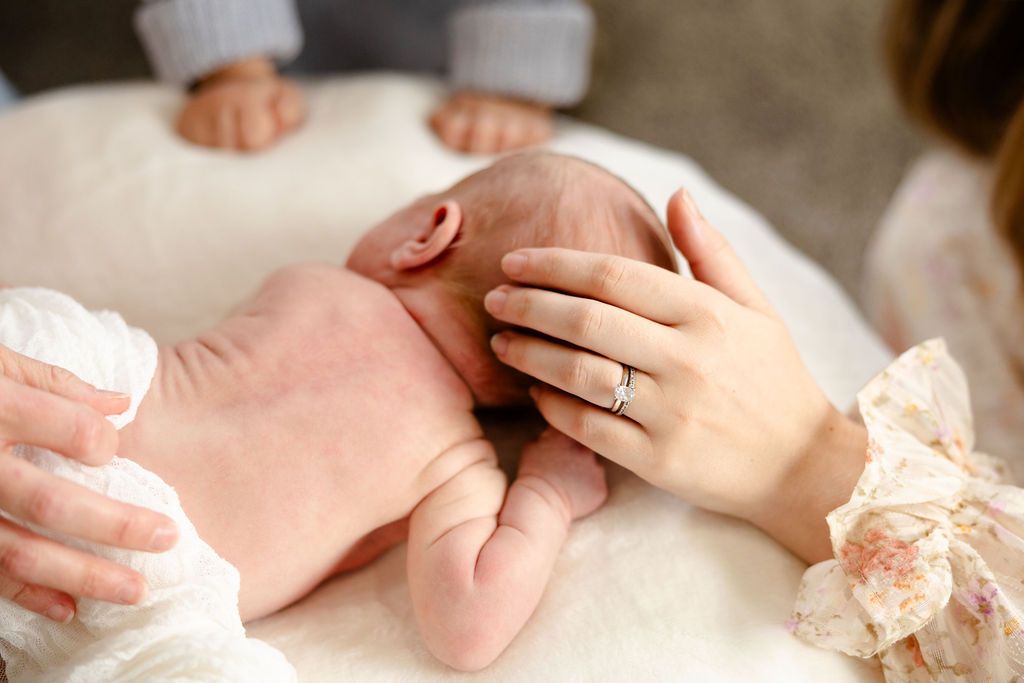 A series of tender moments showing hands gently cradling a newborn baby's tiny feet and body parts.