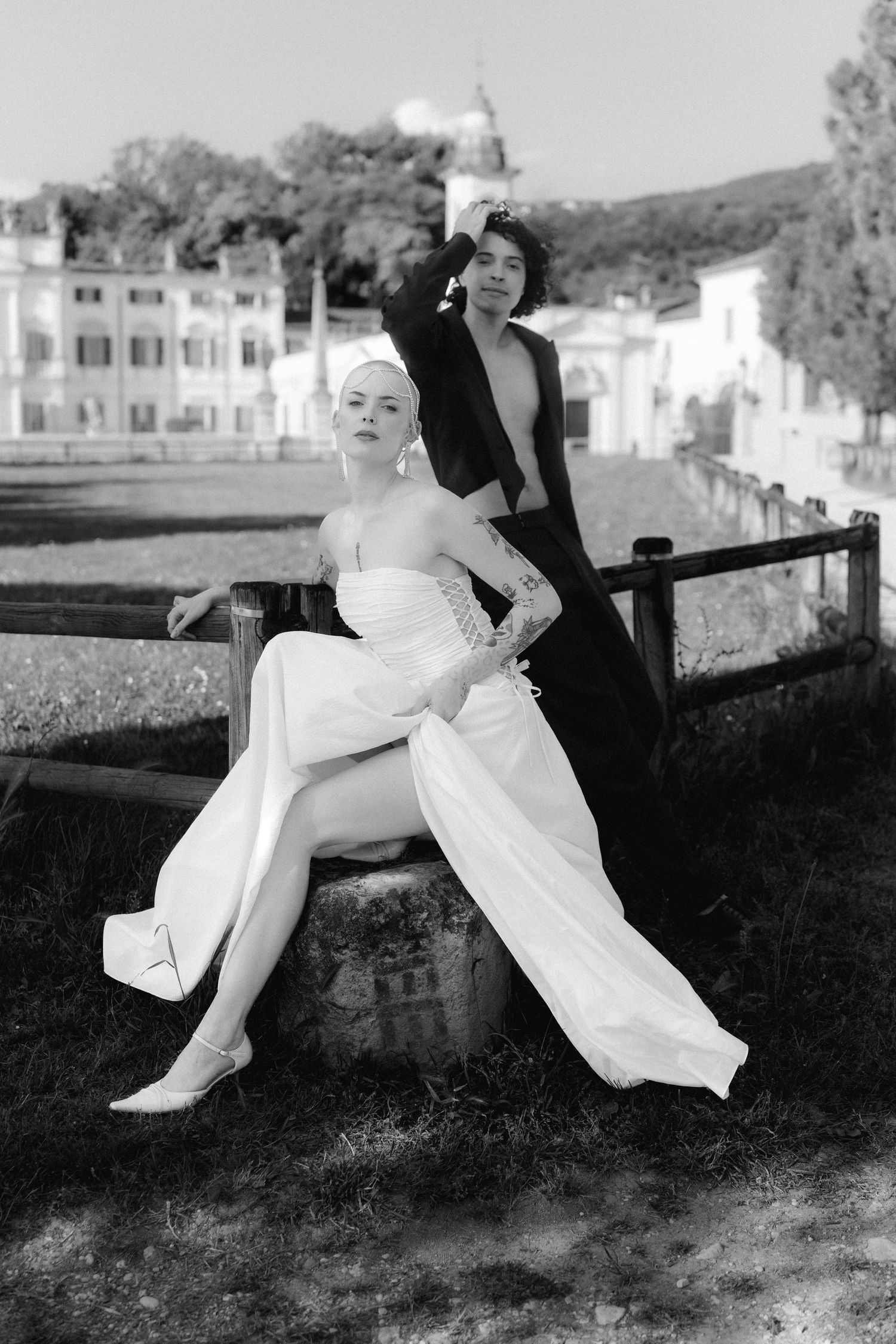Black and white sequence showing someone in a white dress reclining on a railing in four progressive poses.