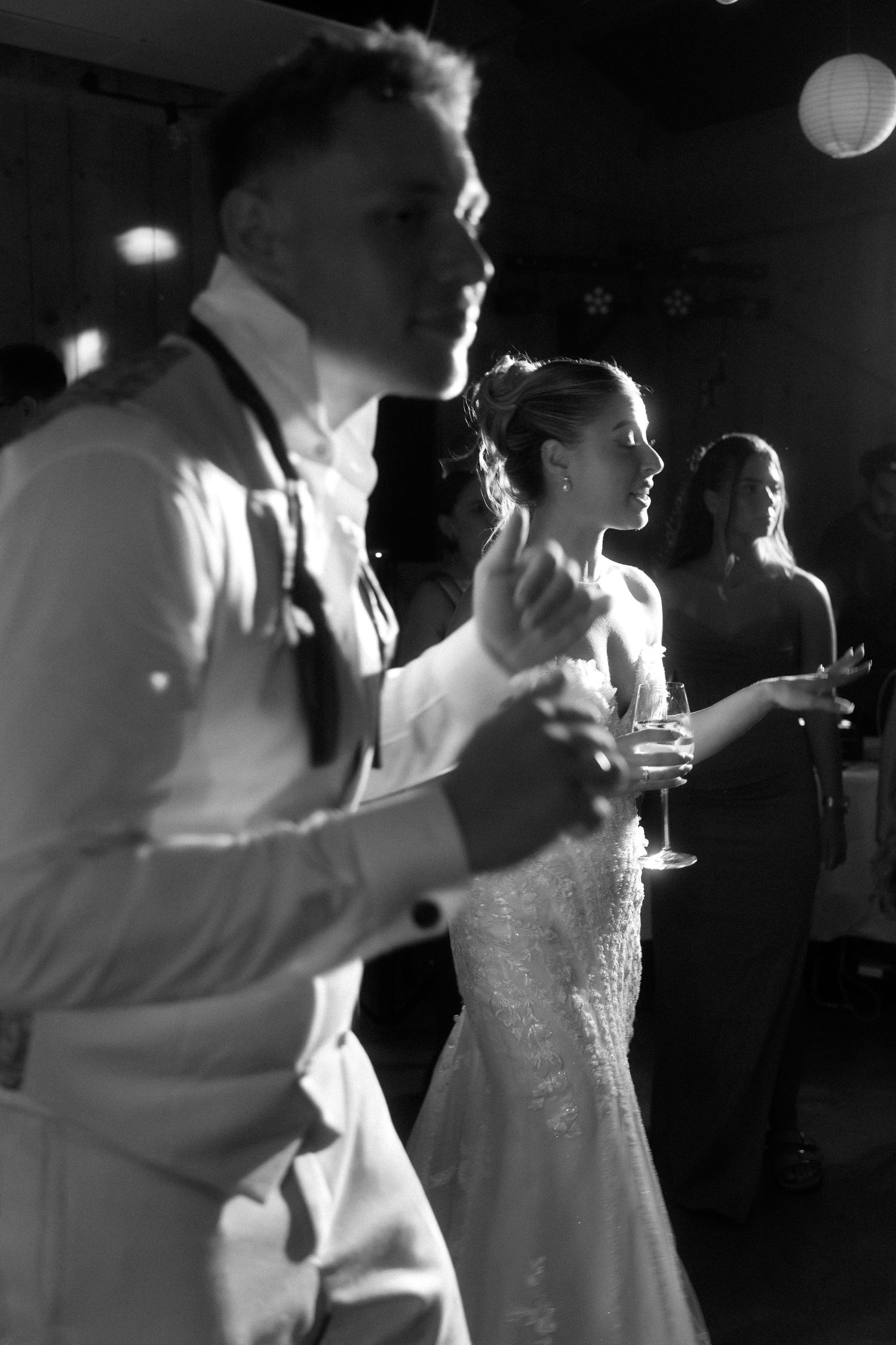 Wedding reception dance party scene in black and white with sparkly dress details.