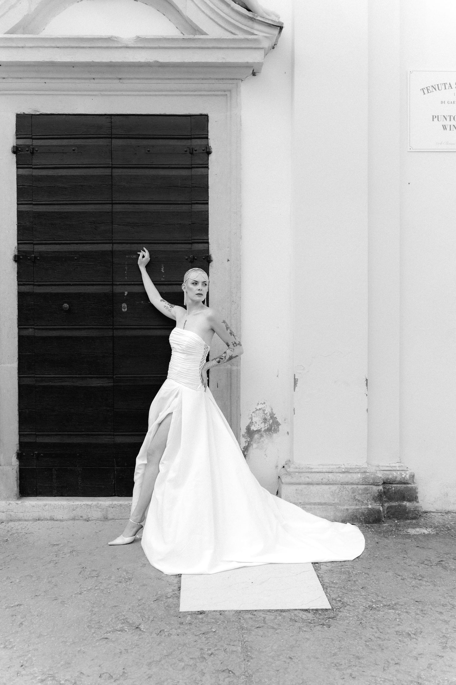 A black and white photo series showing a flowing white wedding dress in graceful motion against a stark building wall.