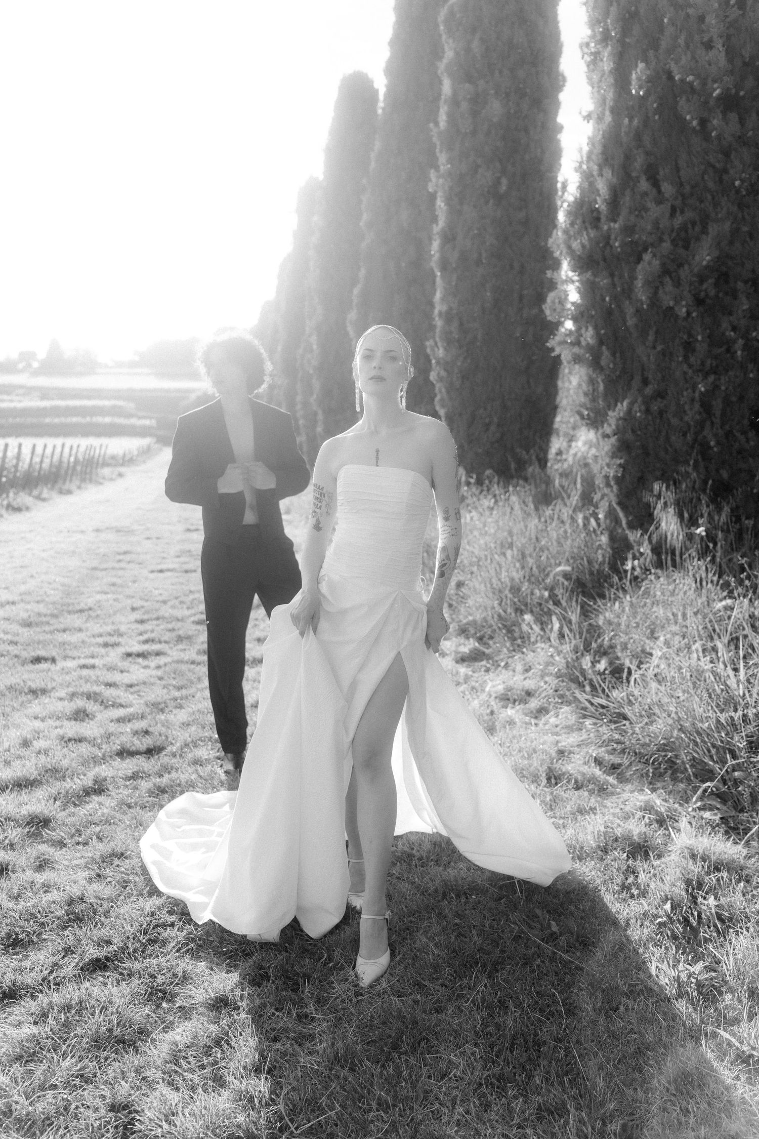 Black and white photo series of a couple walking through a tree-lined path with sunlight filtering through the trees.