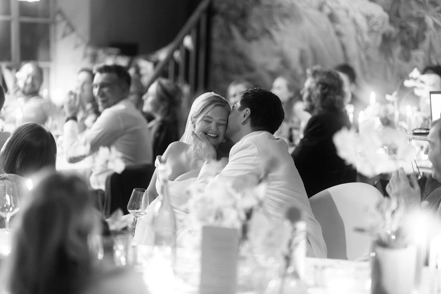 Black and white photo of wedding guests reacting emotionally during a reception.