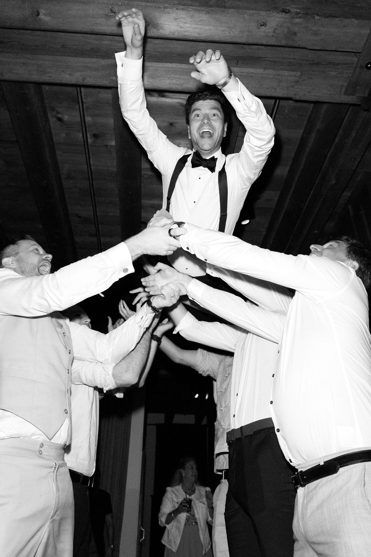 A sequence of black and white photos showing two people in white formal attire dancing energetically at a party.