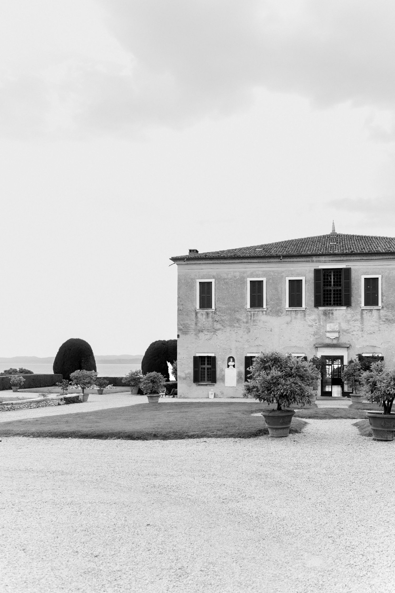 Black and white panoramic view of rustic farmhouses with tiled roofs on a vast empty landscape.