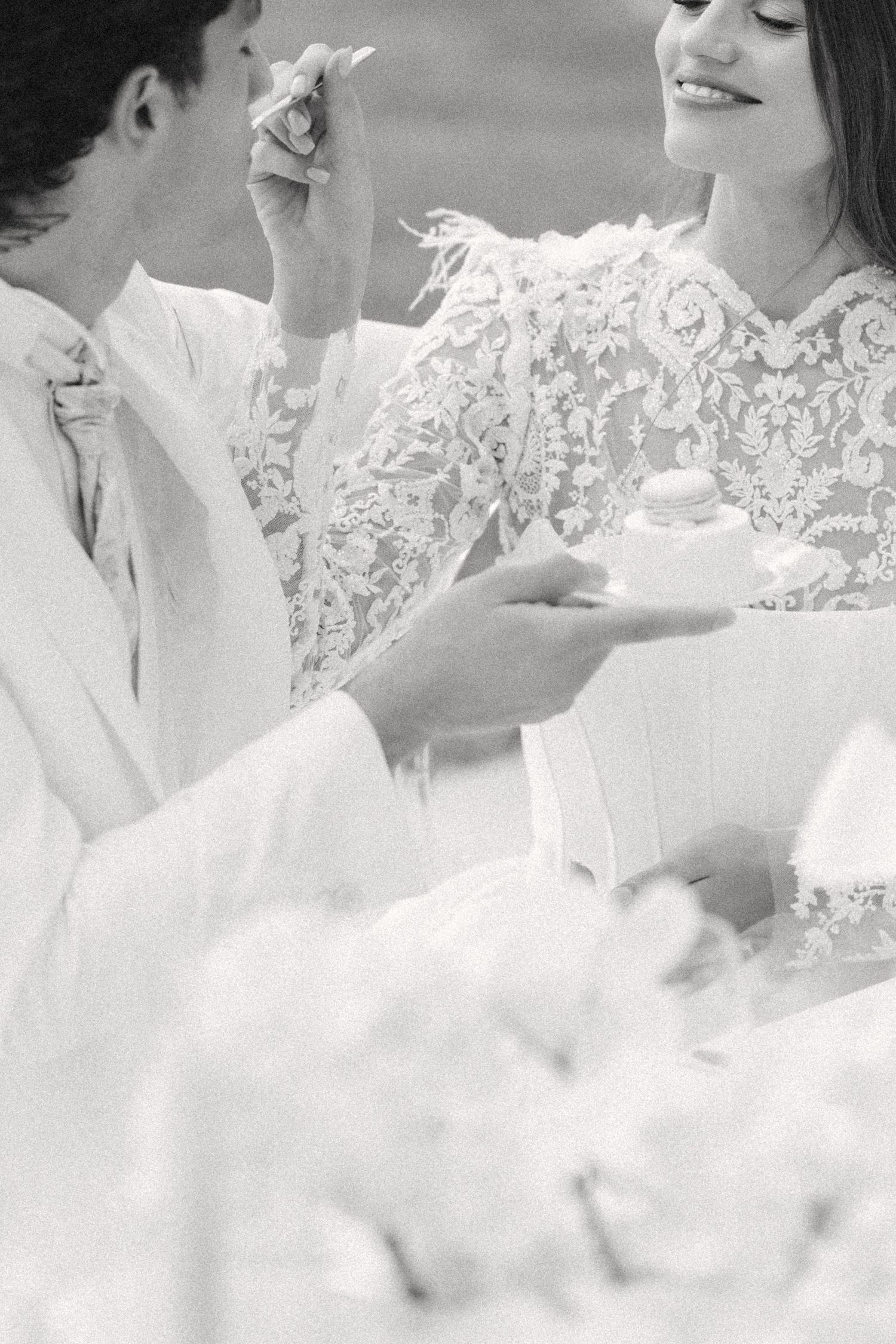 A romantic black and white photo of a couple sharing cake at what appears to be a wedding celebration. Villa Mosconi Bertani
