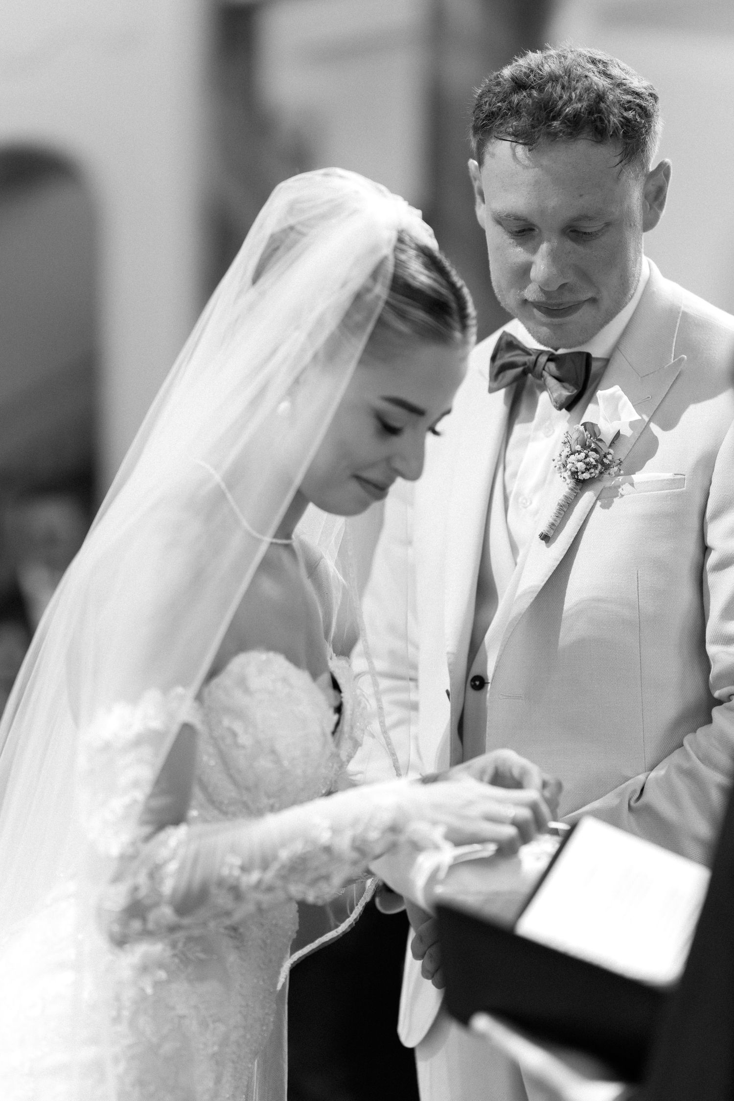 A series of black and white wedding photos showing intimate moments between a bride and groom signing documents.