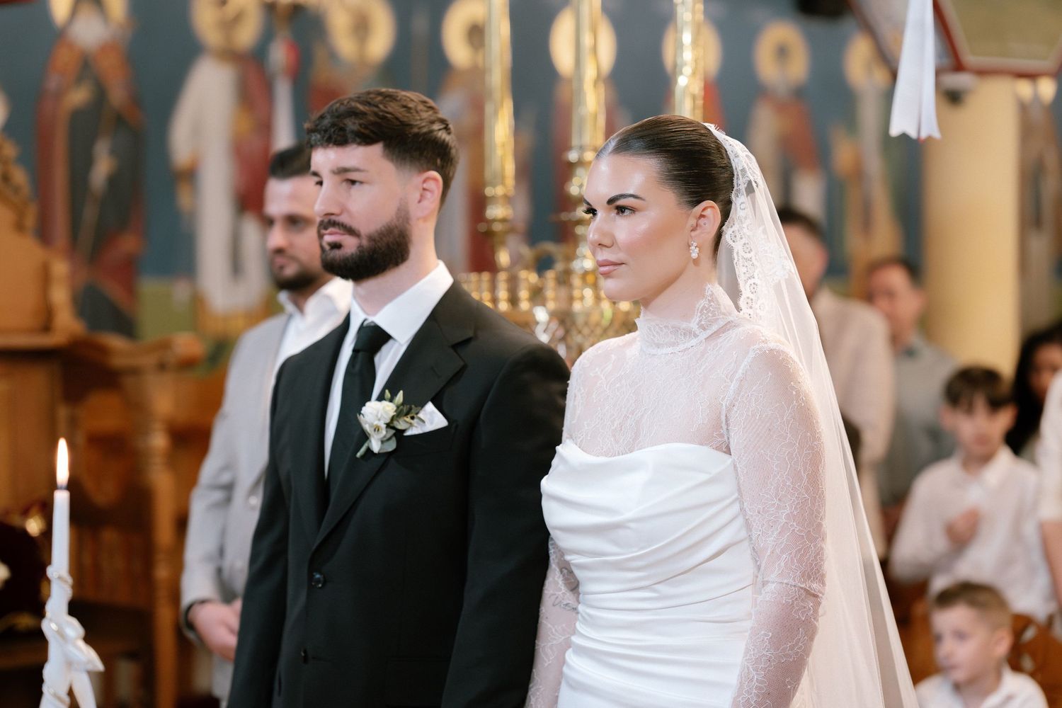 Bride and groom standing at the altar during a traditional church wedding ceremony, bride wearing a white gown with veil.