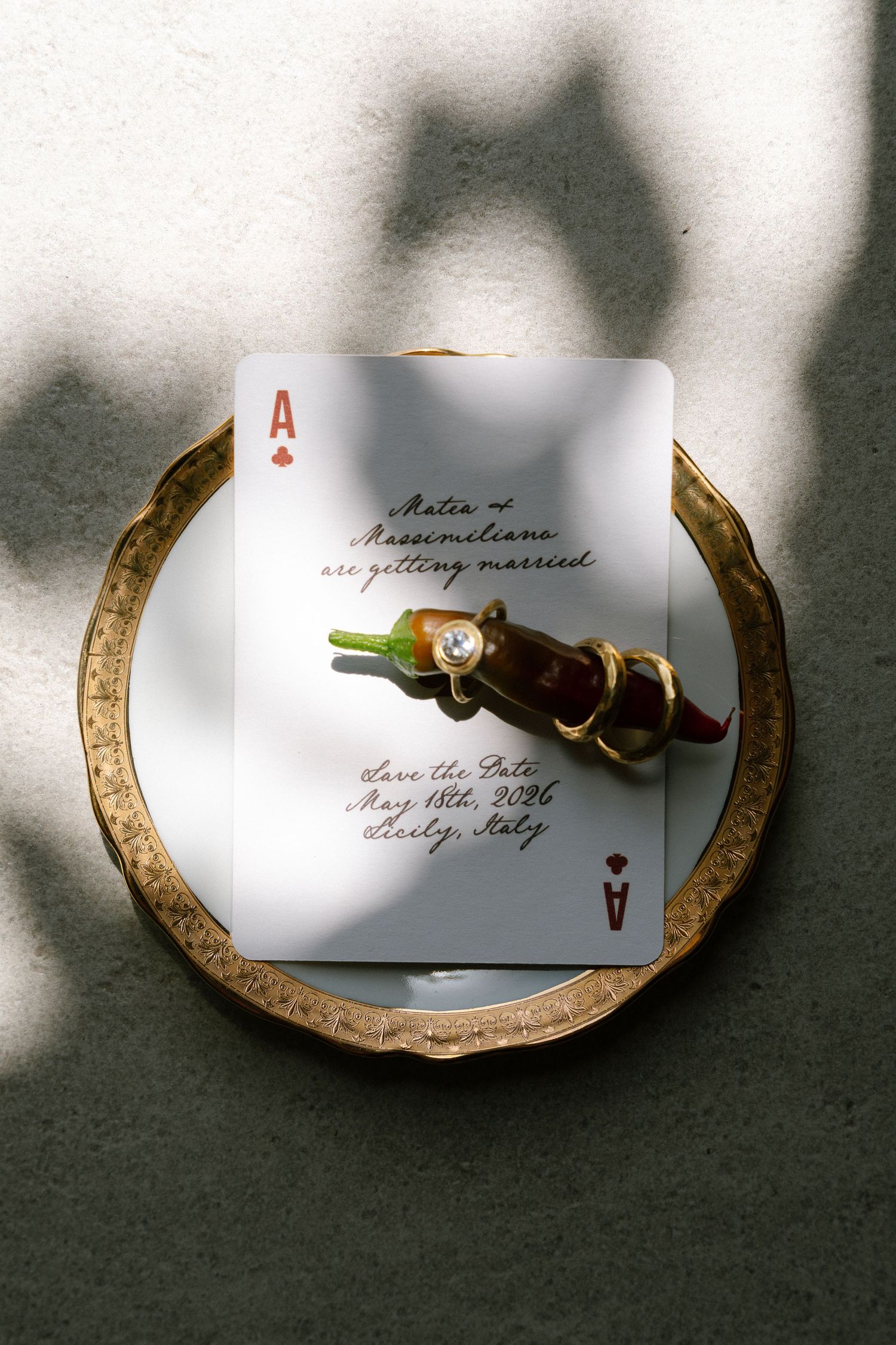 Gold tray with ace of hearts save the date card for a Sicily Italy wedding, adorned with diamond engagement ring.