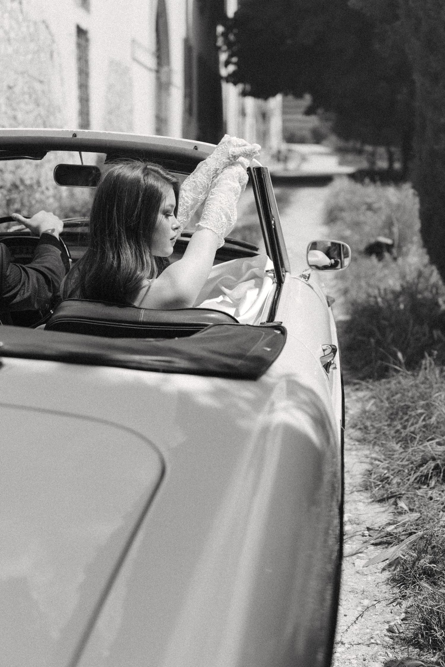 Black and white photo series showing someone resting their arm on a classic car door while lying down.