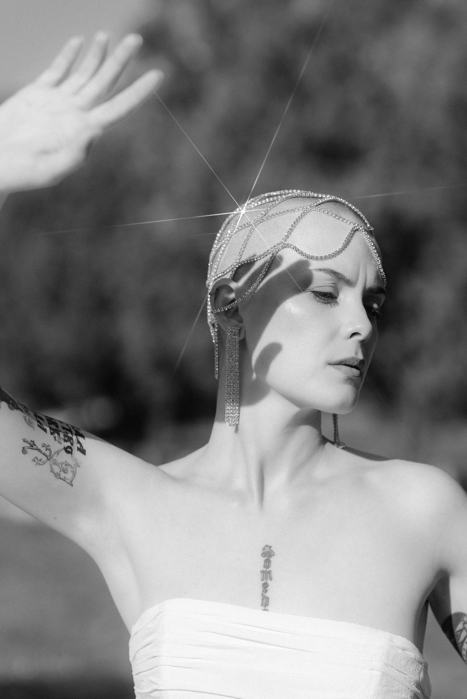 A black and white artistic photo series showing a model in elegant poses wearing a strapless gown and jewelry.