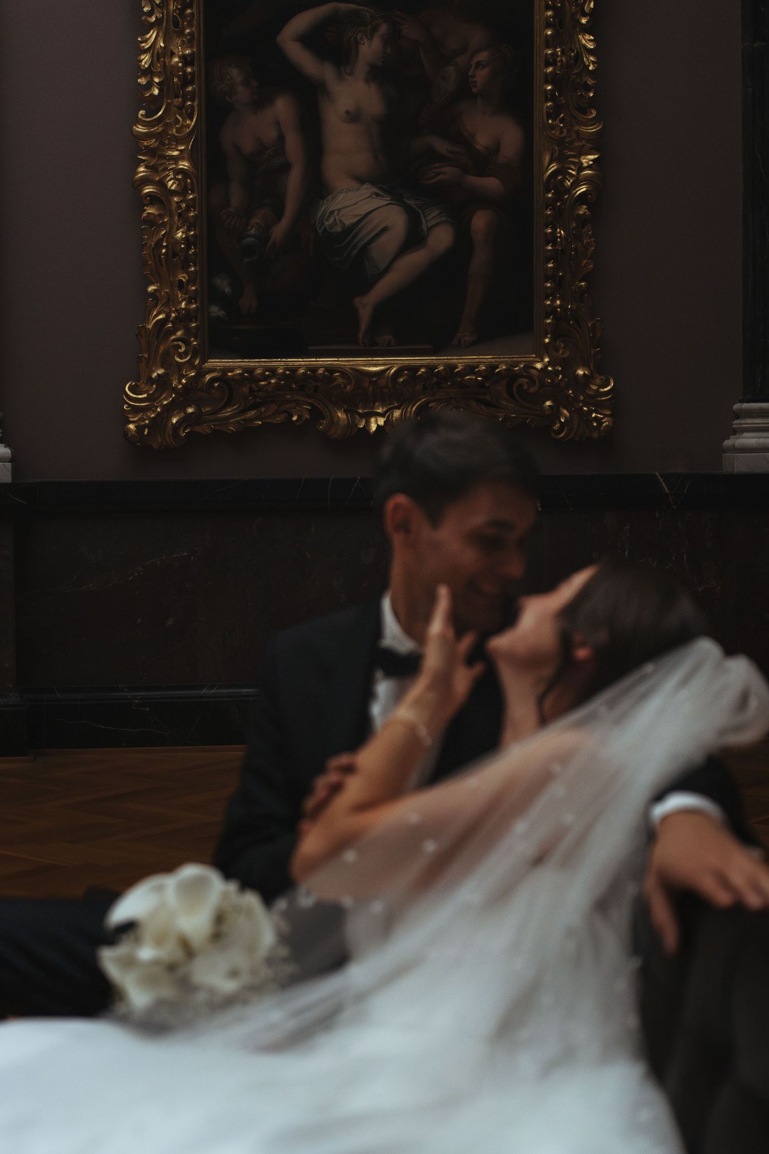 Artistic wedding photo with classic artwork and romantic pose.