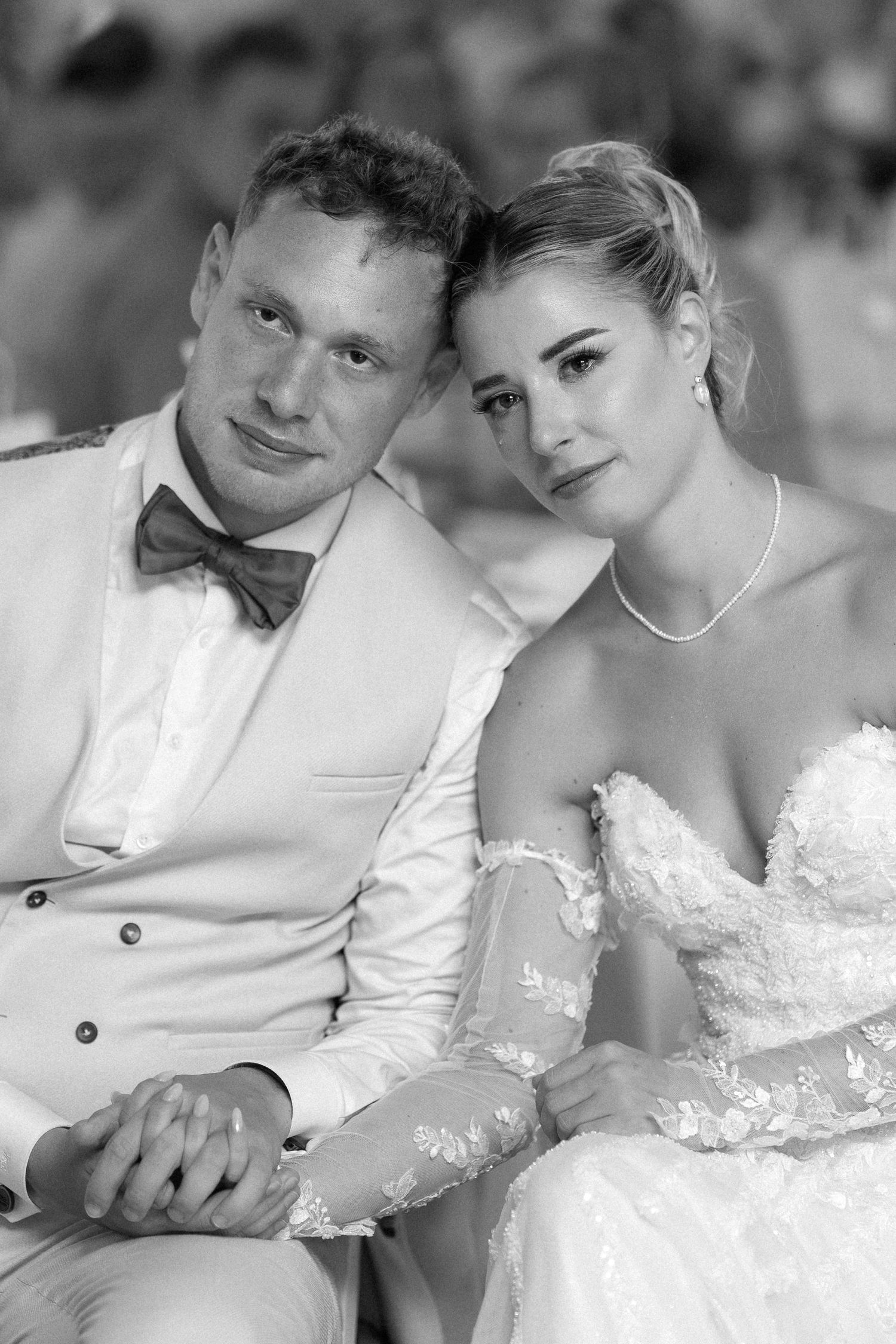 A romantic black and white photo series showing a couple in wedding attire sharing intimate moments together.