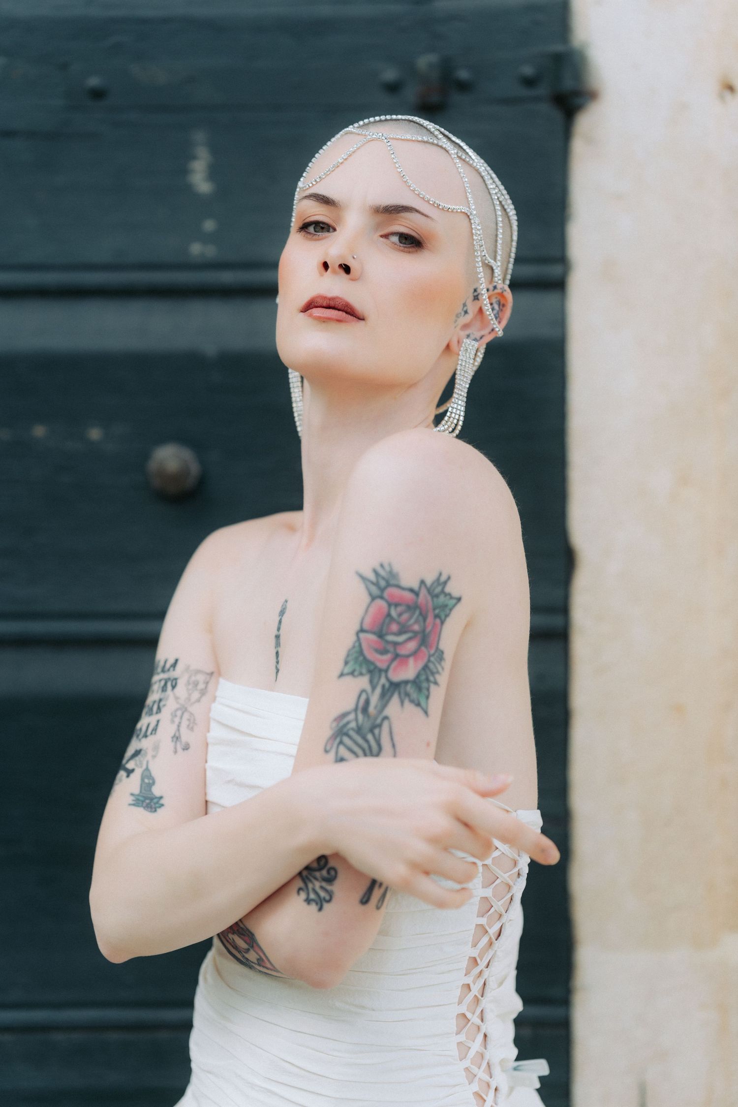 Artistic photo series showing a person in white dress with visible tattoos posing against dark background.