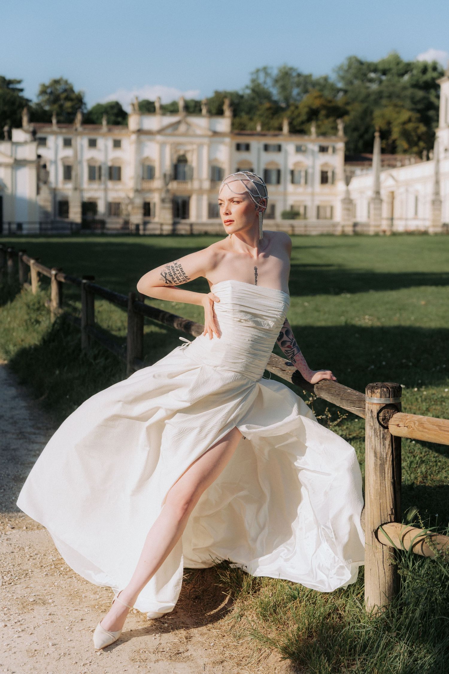 A white wedding dress flows gracefully in a series of outdoor poses against a historic mansion backdrop.