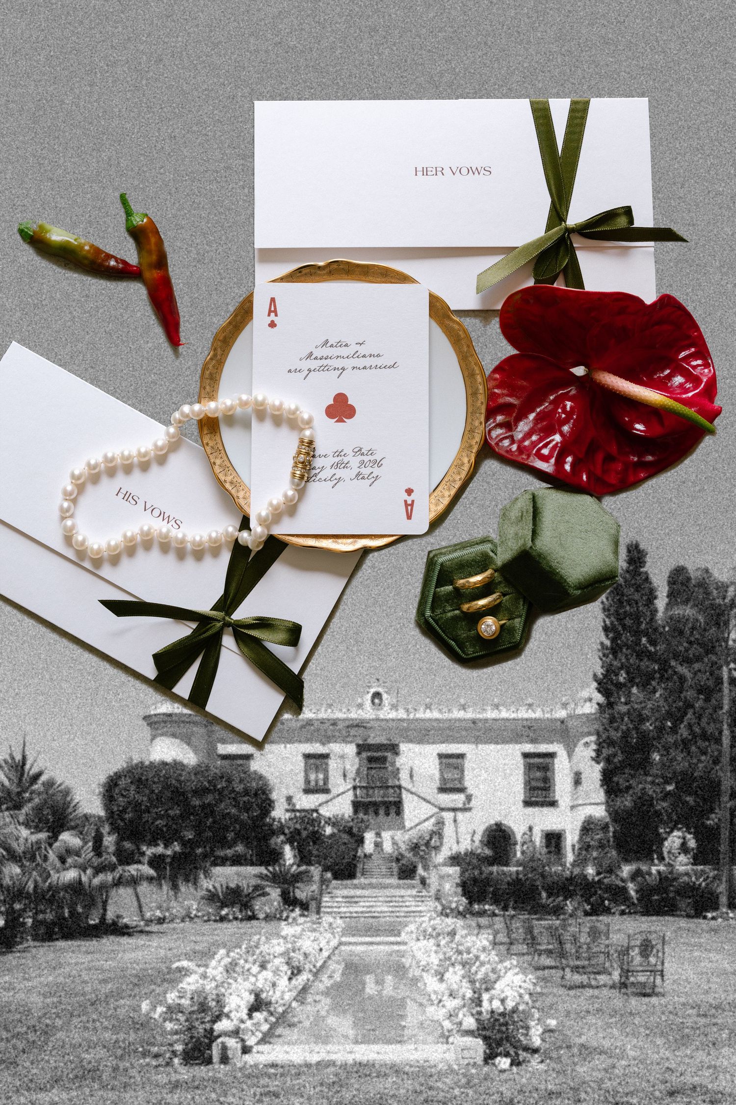 Elegant wedding flat lay with pearl bracelet, ring box, invitations, red anthurium, and chili peppers on a vintage estate backdrop.
