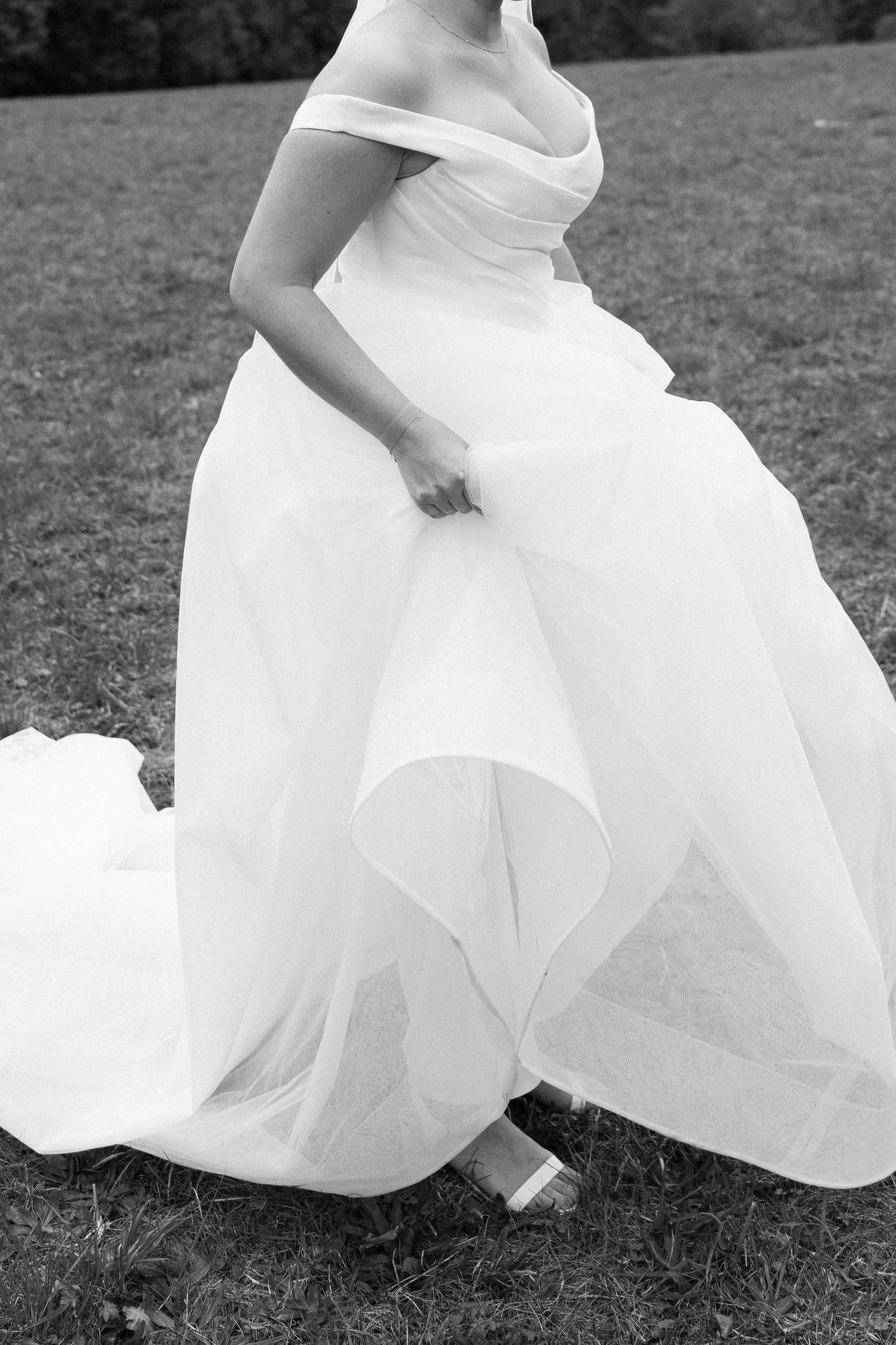 Black and white artistic series showing flowing white wedding dress fabric against grass in multiple cropped detail shots.