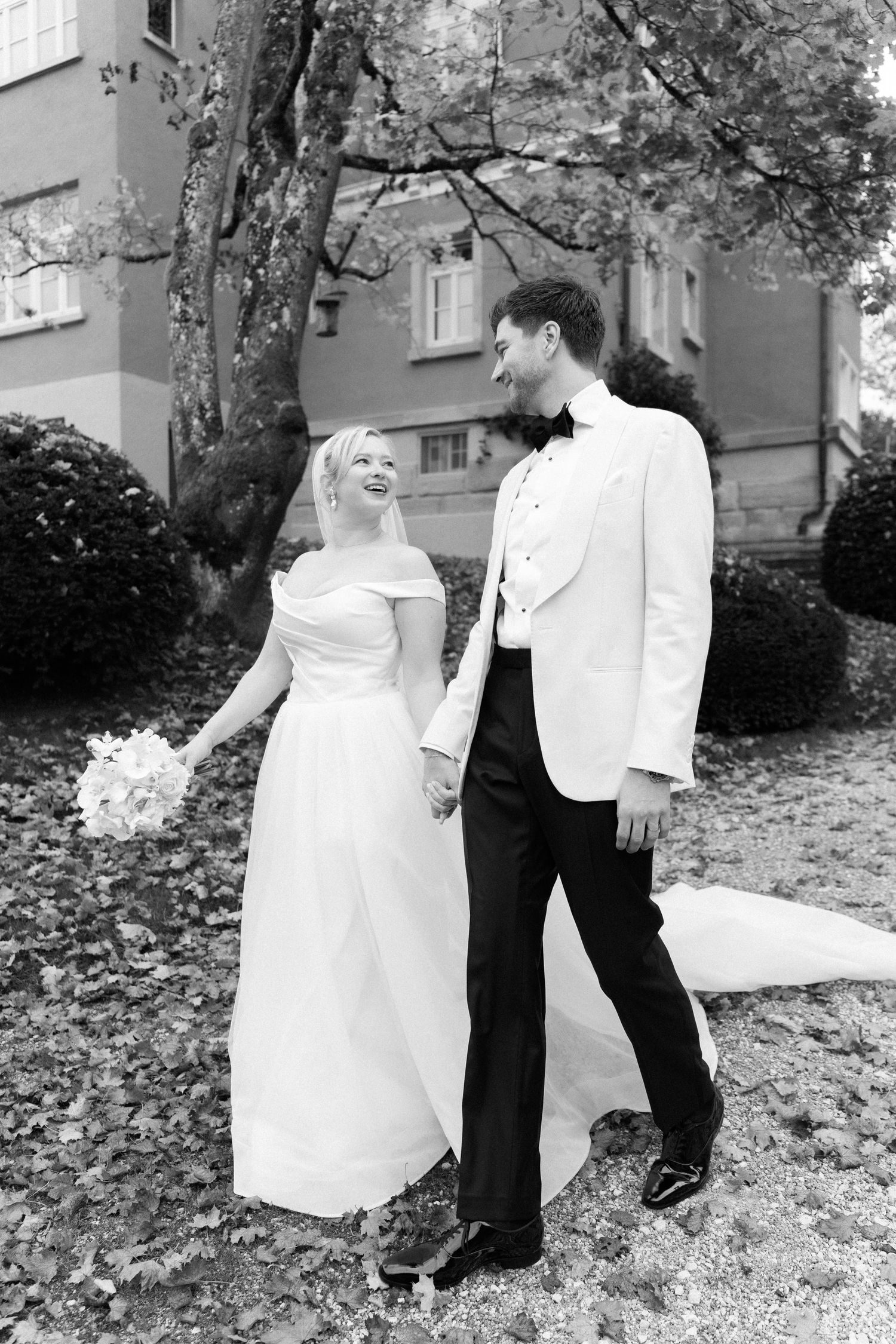 A black and white photo series shows a couple in wedding attire playfully dancing and twirling outdoors.
